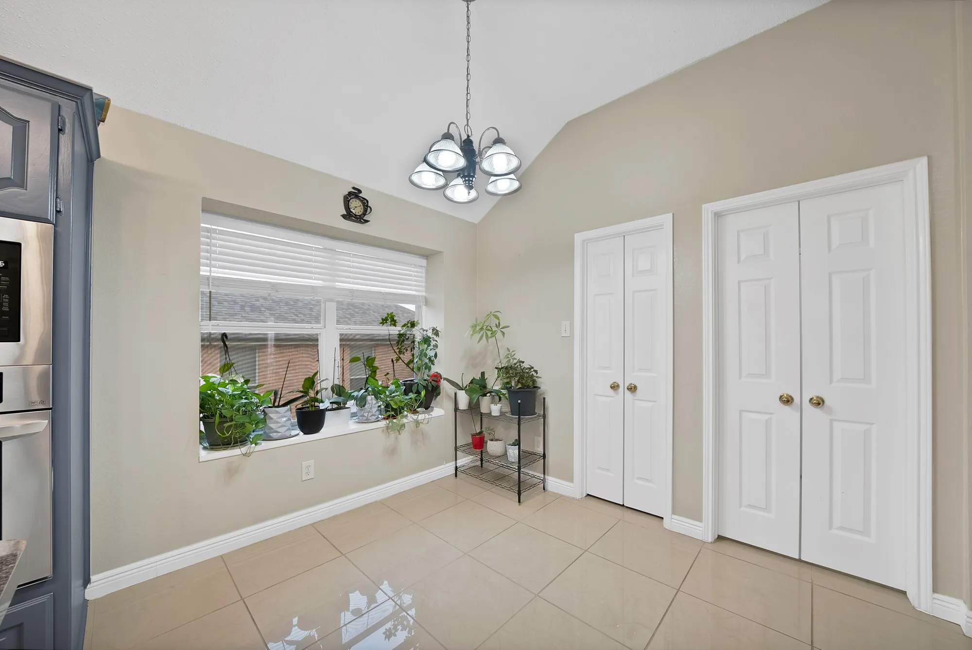 Unfurnished dining area with vaulted ceiling, a chandelier, and light tile patterned floors