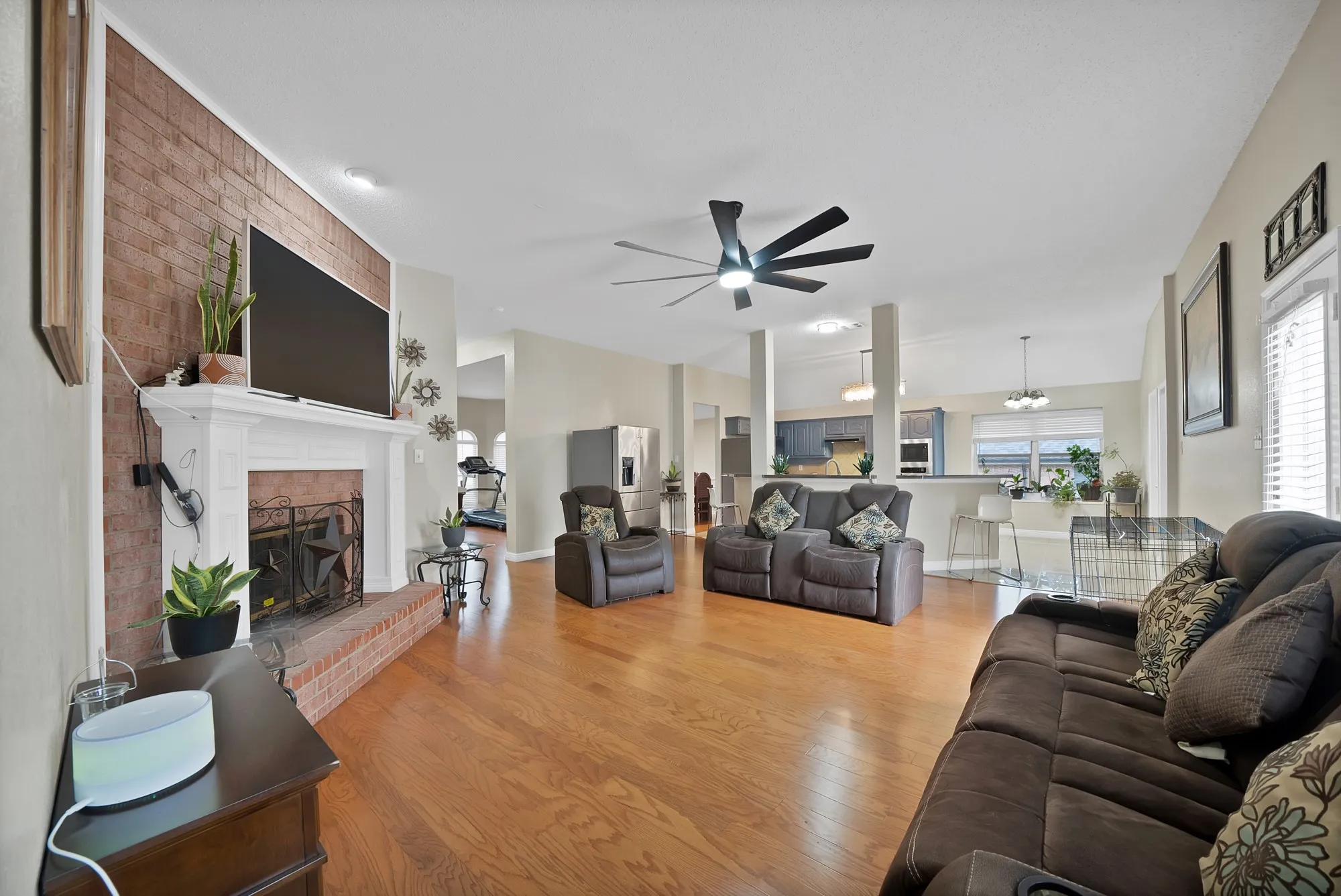 Living area featuring a fireplace, light wood-style floors, and a ceiling fan