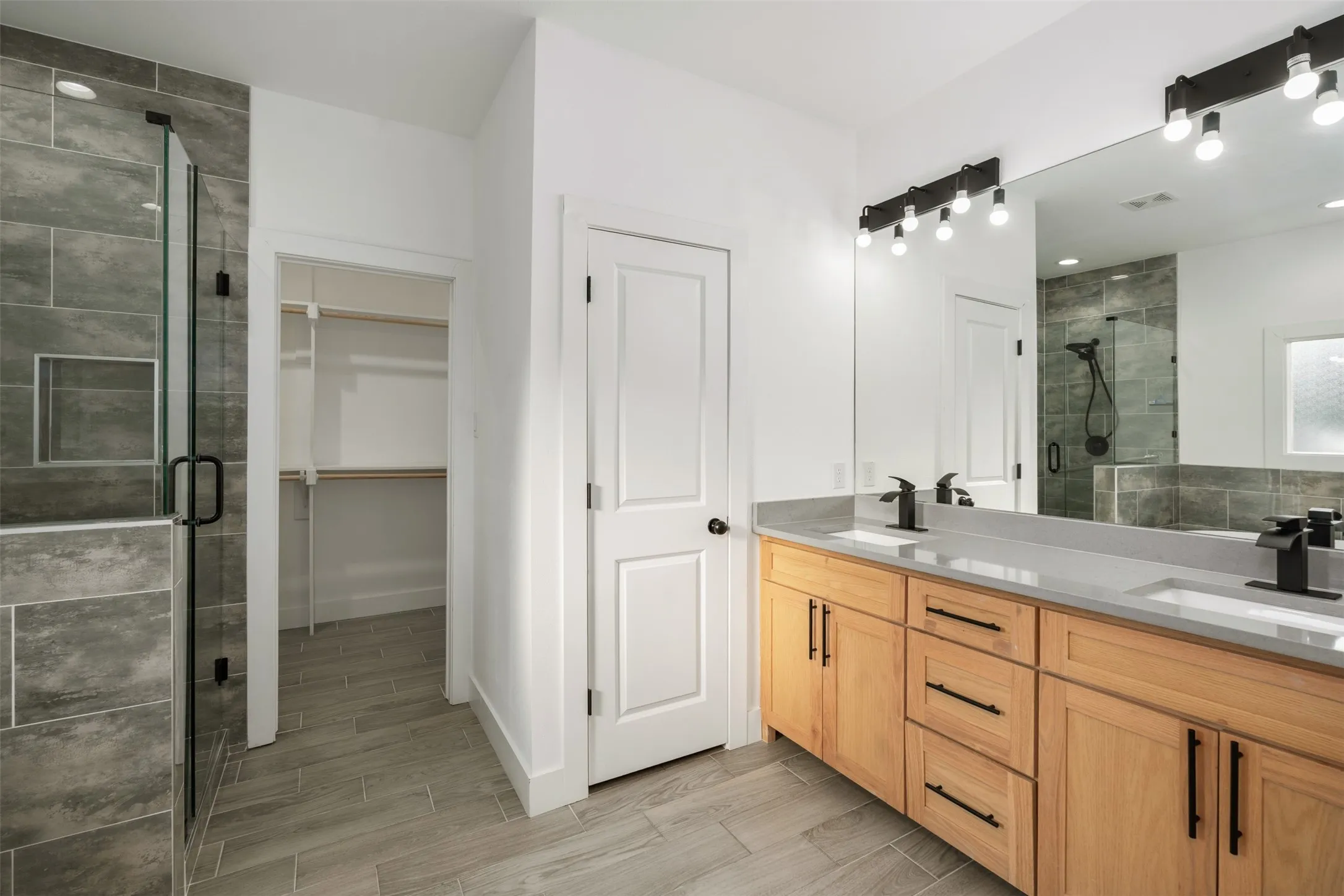 Primary bath with dual sinks, shower and large walk in closet