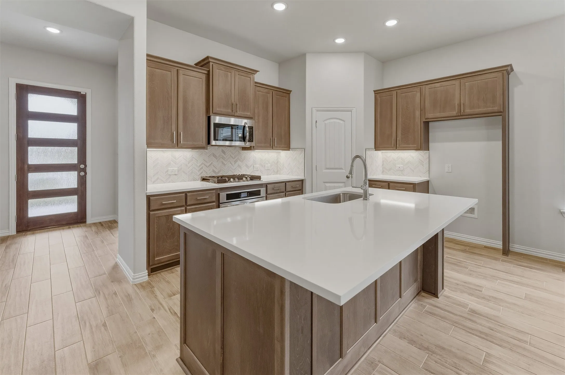 Central kitchen island with a white countertop and integrated sink