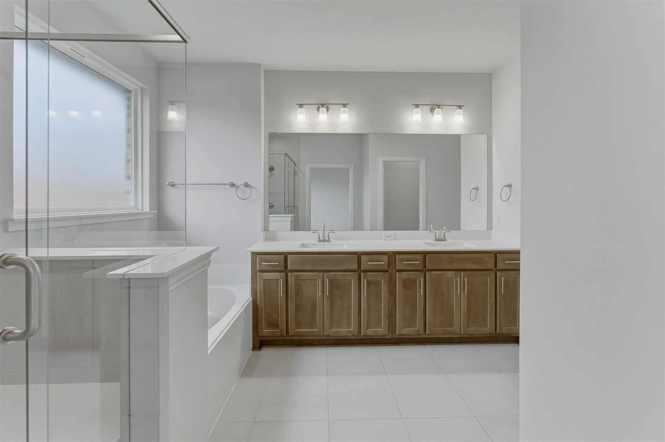 Contemporary bathroom featuring a spacious dual vanity with wood-finish cabinetry and a framed mirror