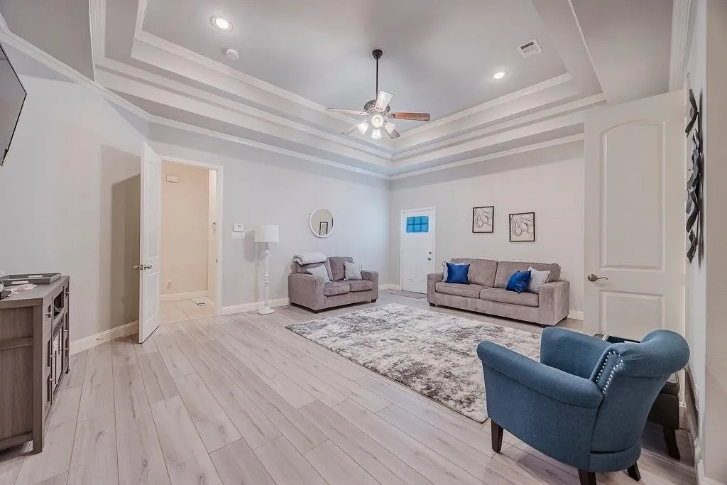 Living area featuring ceiling fan, light wood-style flooring, crown molding, and recessed lighting