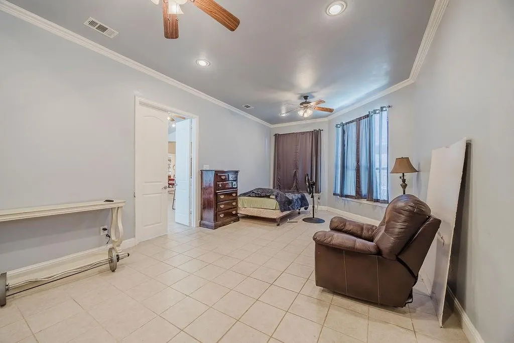 Living area with ceiling fan, ornamental molding, light tile patterned floors, and recessed lighting