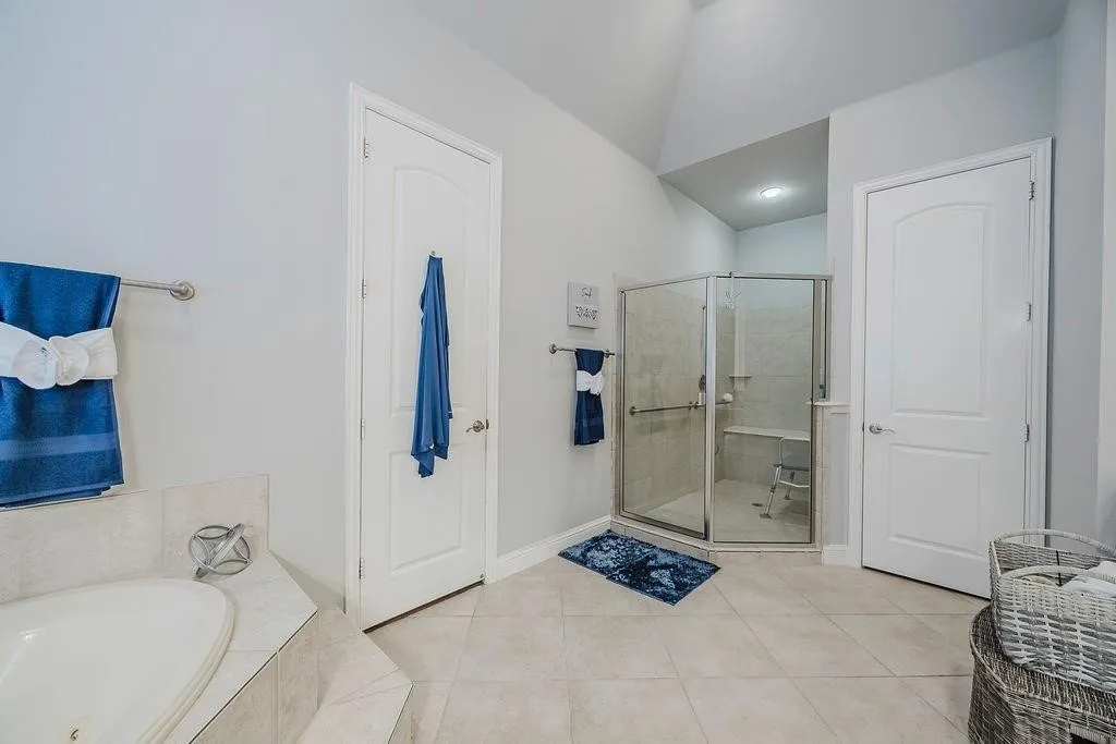 Full bath with a garden tub, light tile patterned flooring, and a shower stall
