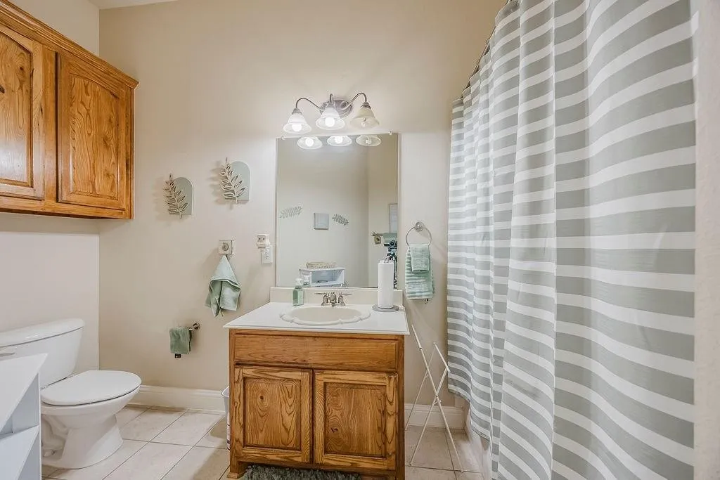 Full bath featuring vanity, a shower with shower curtain, and light tile patterned floors