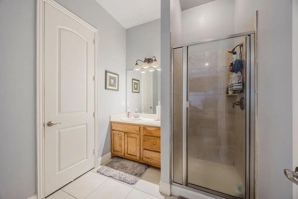 Bathroom with a stall shower, vanity, and light tile patterned floors
