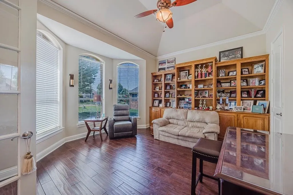 Office featuring ceiling fan, ornamental molding, dark wood-style flooring, and vaulted ceiling
