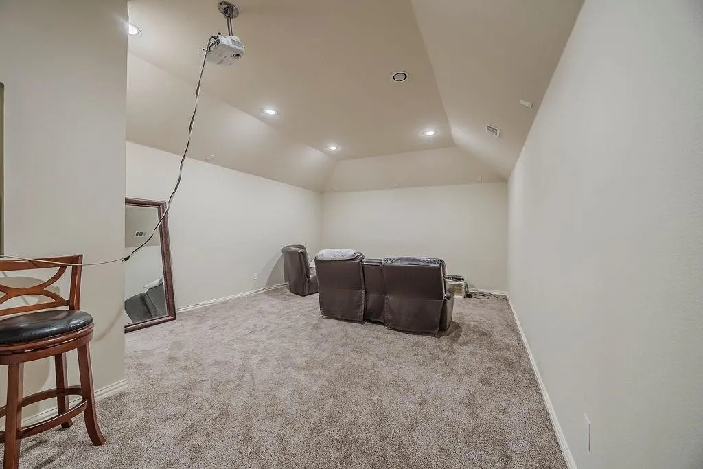 Home theater room featuring recessed lighting, lofted ceiling, and light carpet