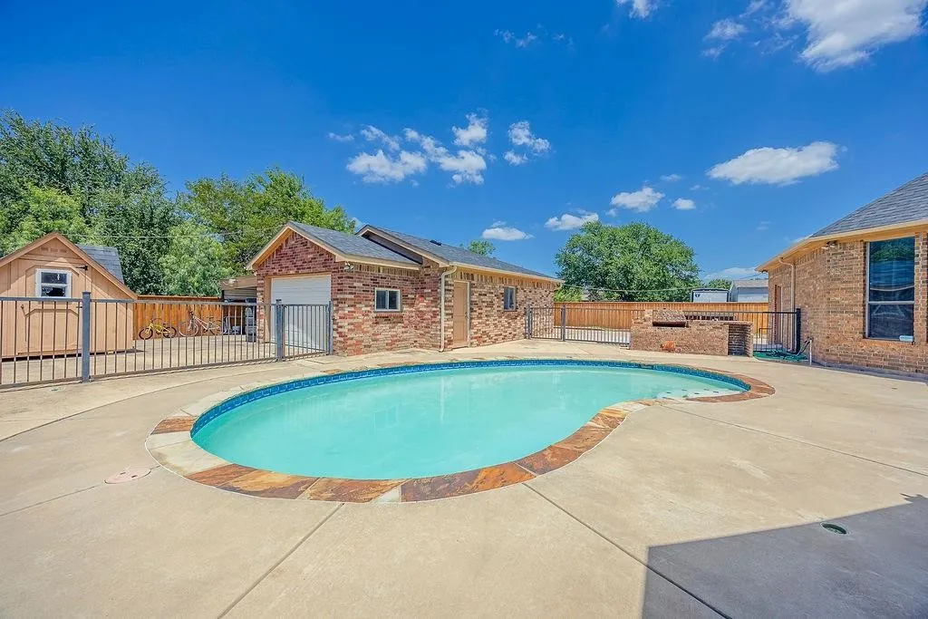 View of pool featuring a shed and patio surround