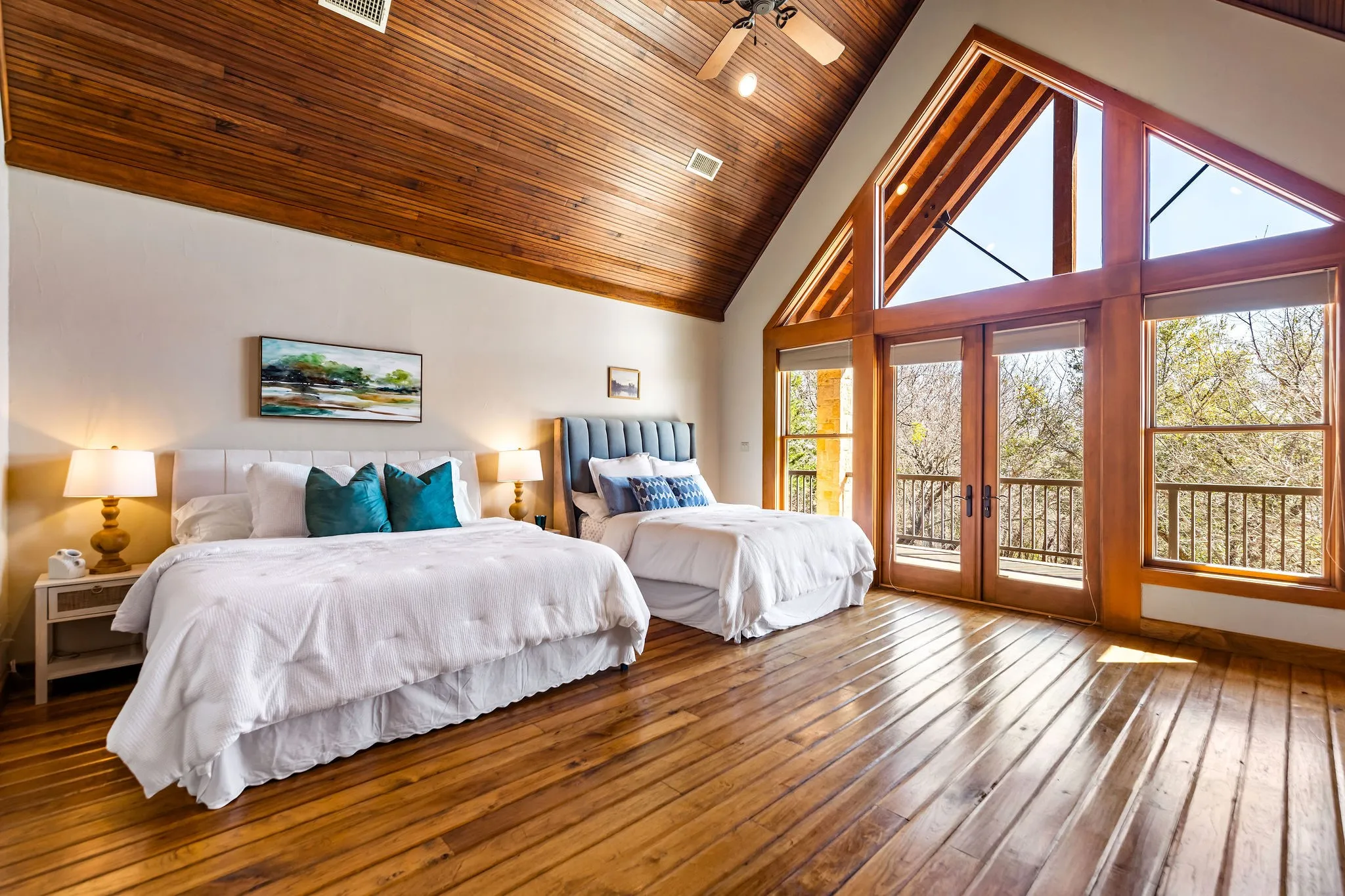 Hill Lodge’s bedroom 2 of 3 features soaring wood ceilings, custom built-ins, and large windows that fill the space with natural light.