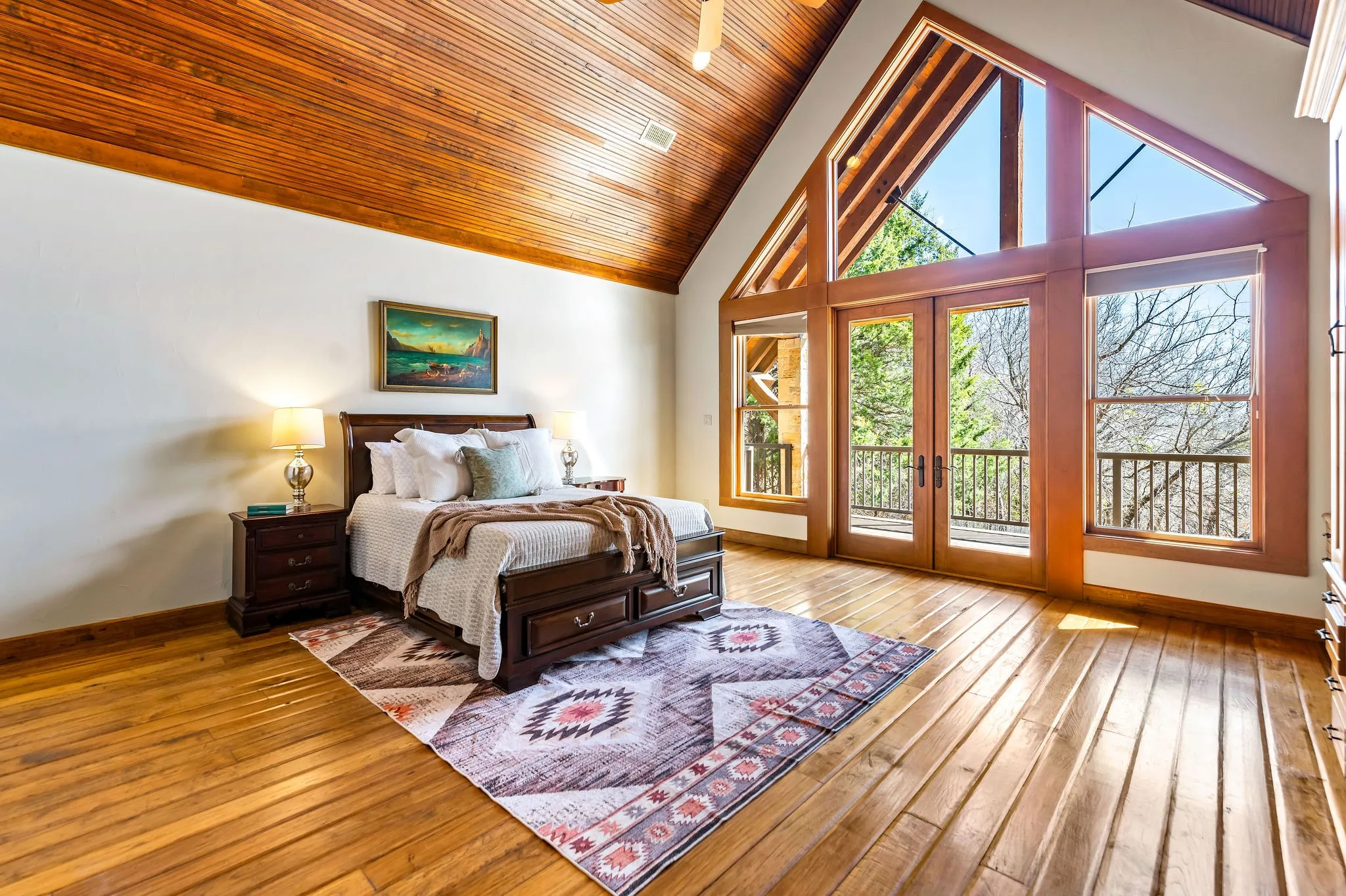 Hill Lodge’s bedroom 3 of 3 features soaring wood ceilings, custom built-ins, and large windows that fill the space with natural light.