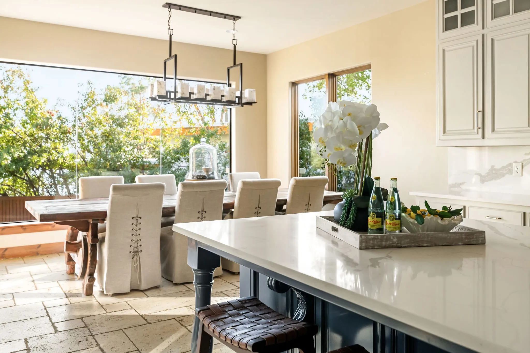 The main house dining room features large table space, stylish seating, and expansive windows that bring in natural light.