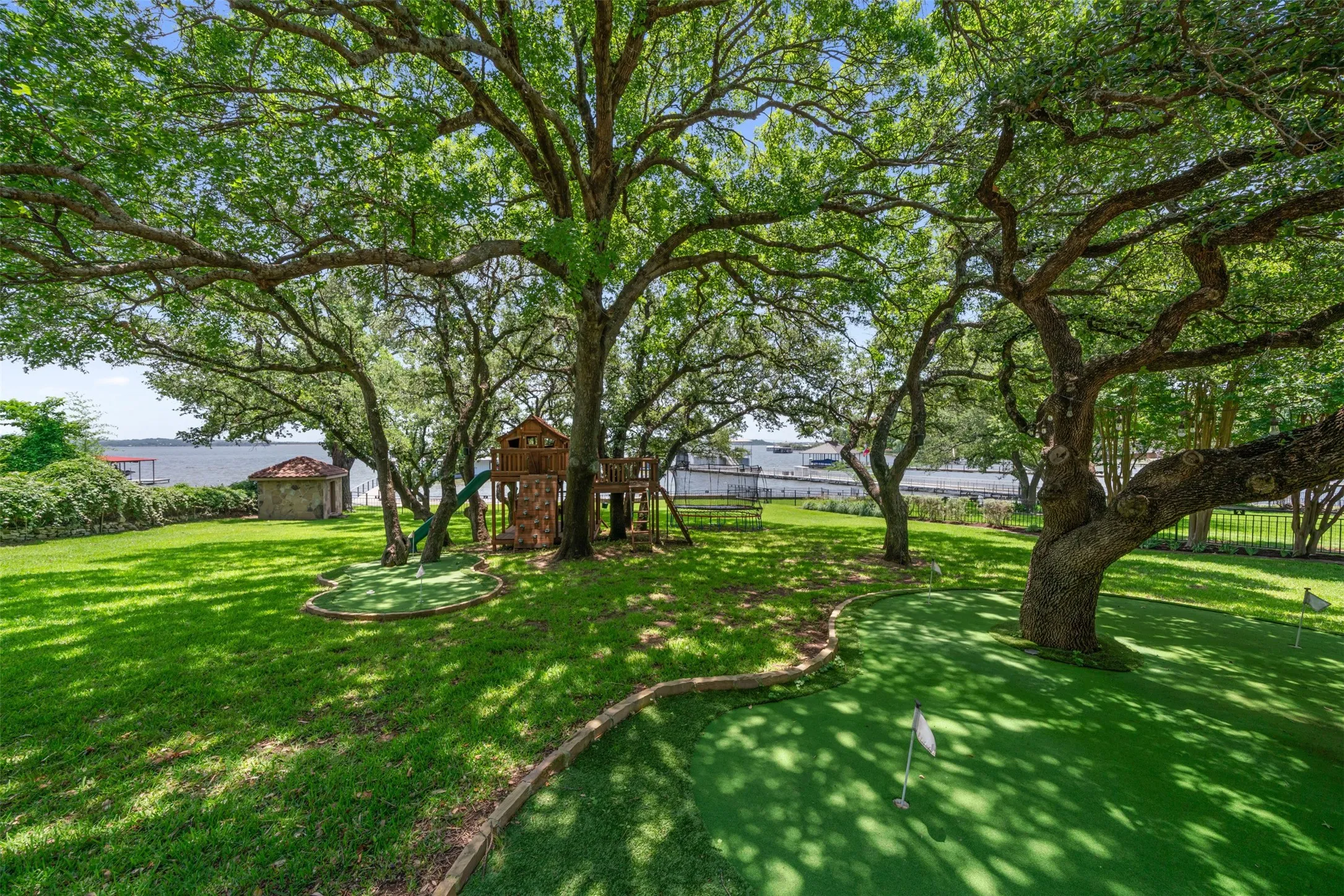 Enjoy a beautifully landscaped backyard at the primary residence with putting greens, mature oak trees, and scenic views of the lake.