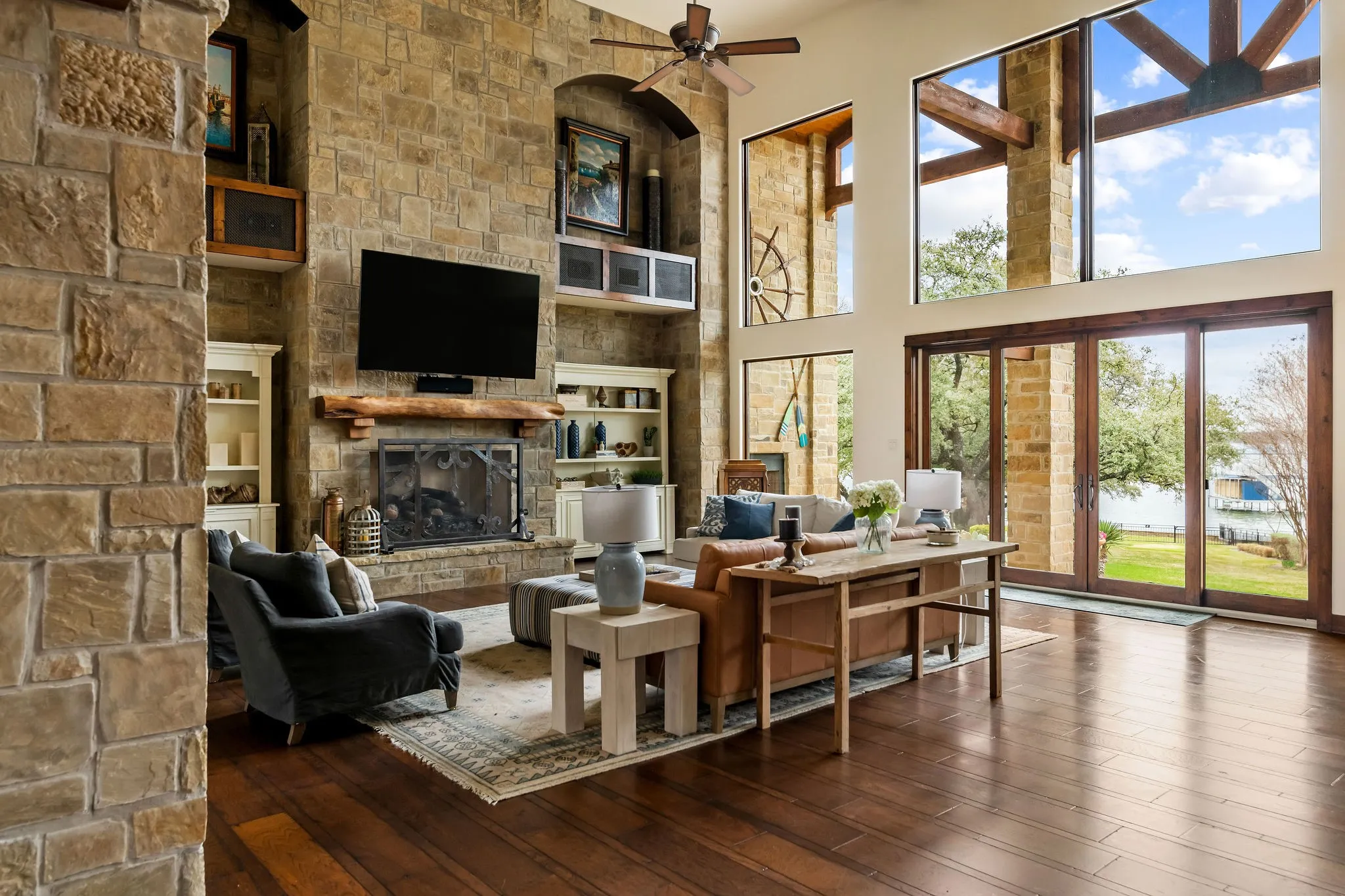 Main residence great room features beamed sky-high ceilings and floor to ceiling windows providing stunning views of the water.