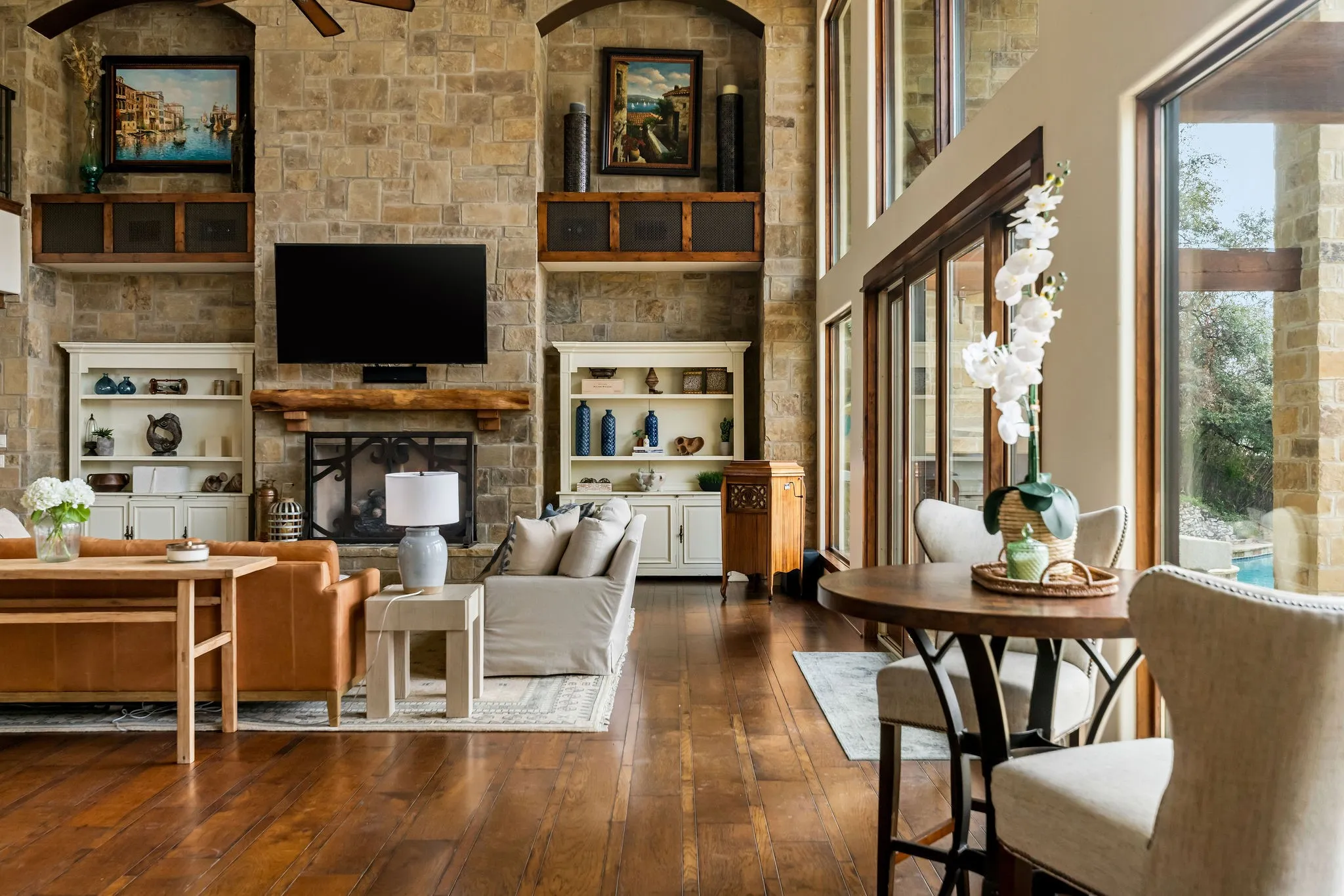 Main residence great room features beamed sky-high ceilings and floor to ceiling windows providing stunning views of the water.