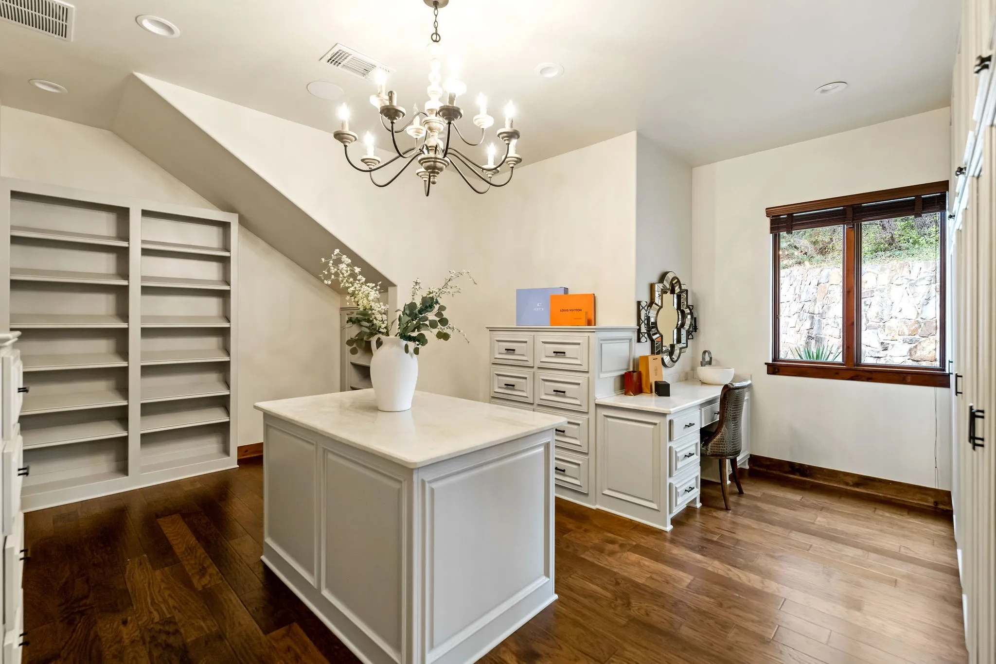 The primary closet in the Main House features custom cabinetry, ample storage, and a beautifully designed center island.