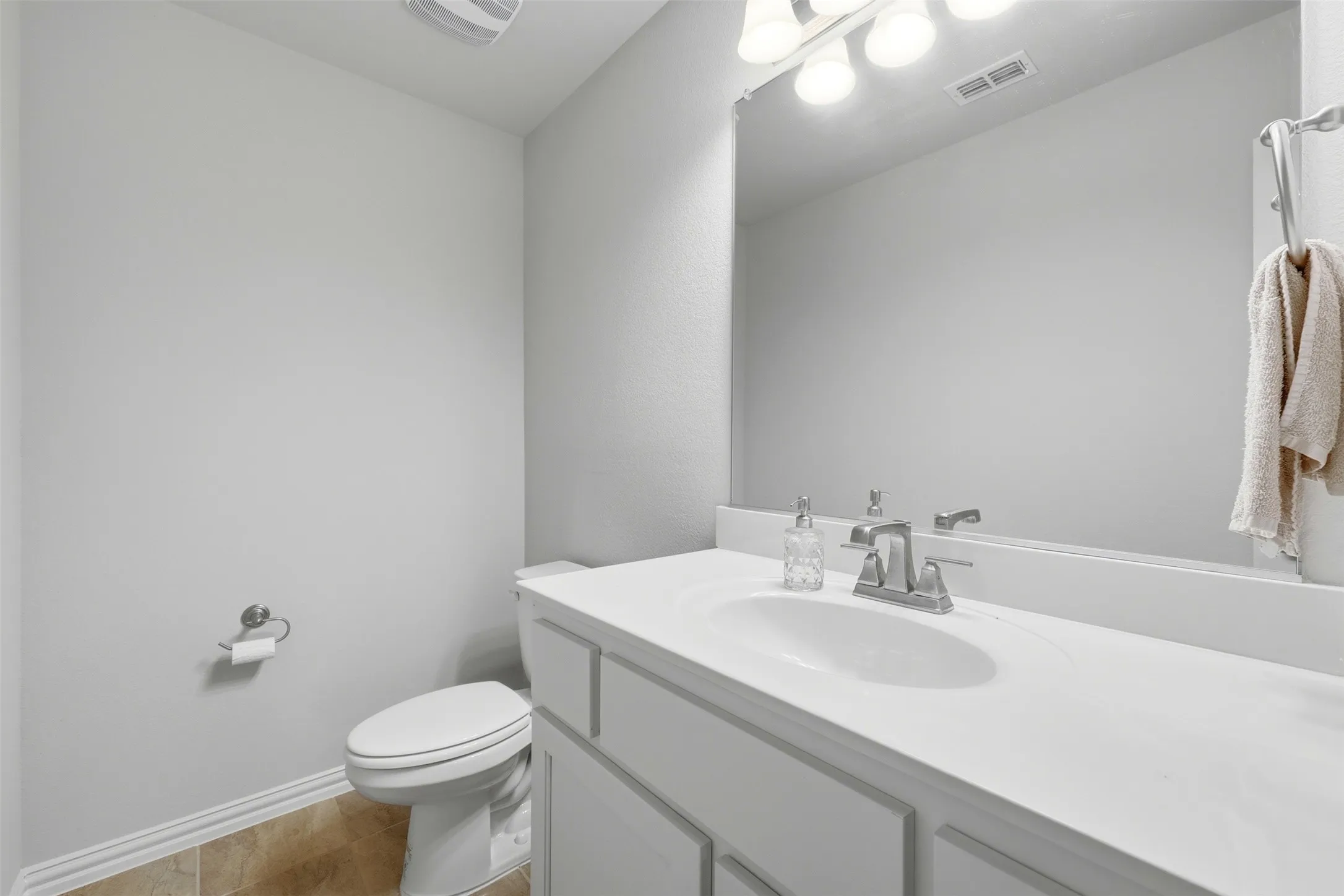 Half bathroom featuring vanity and light tile patterned flooring