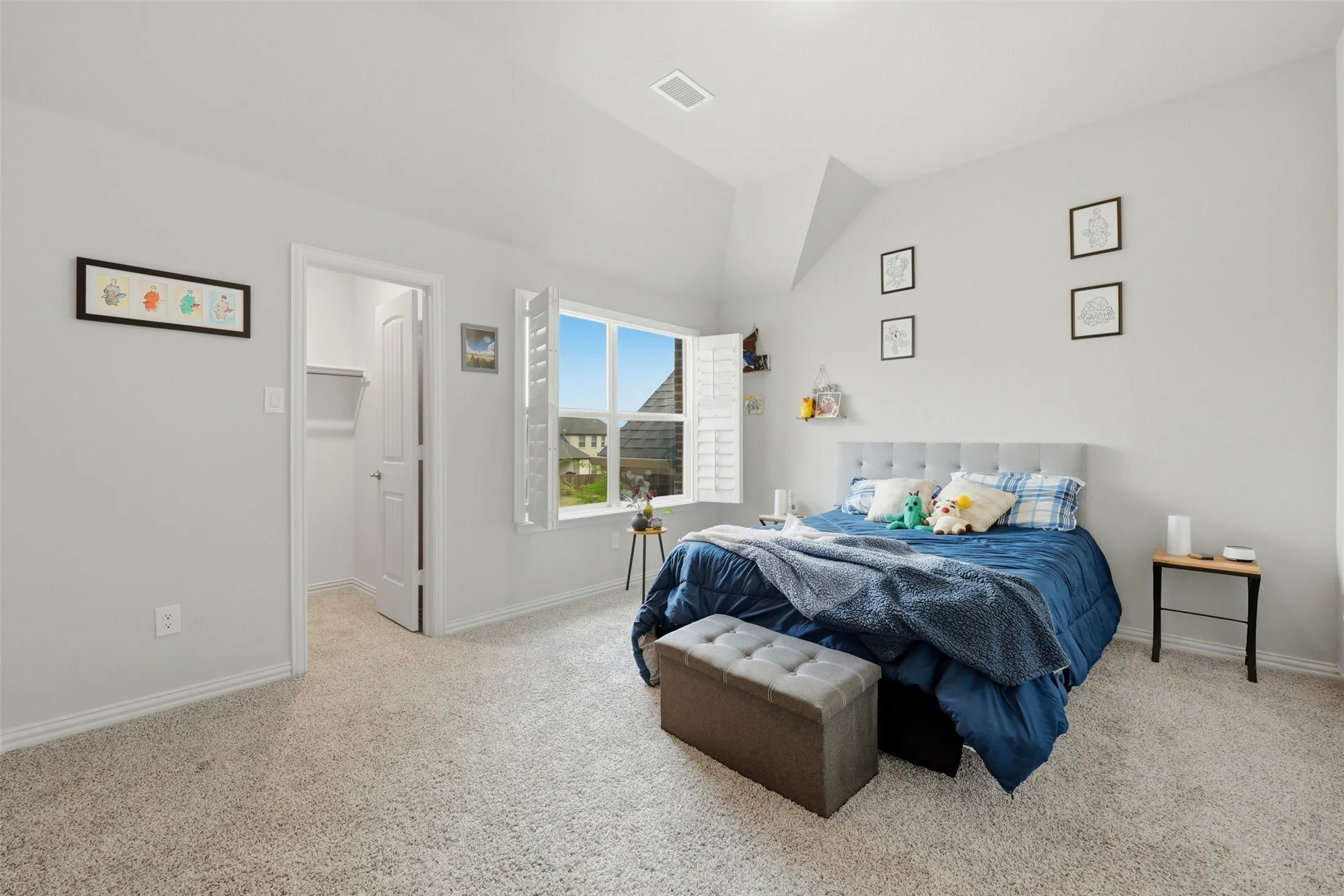 2nd Bedroom with a walk in closet, light carpet, and lofted ceiling