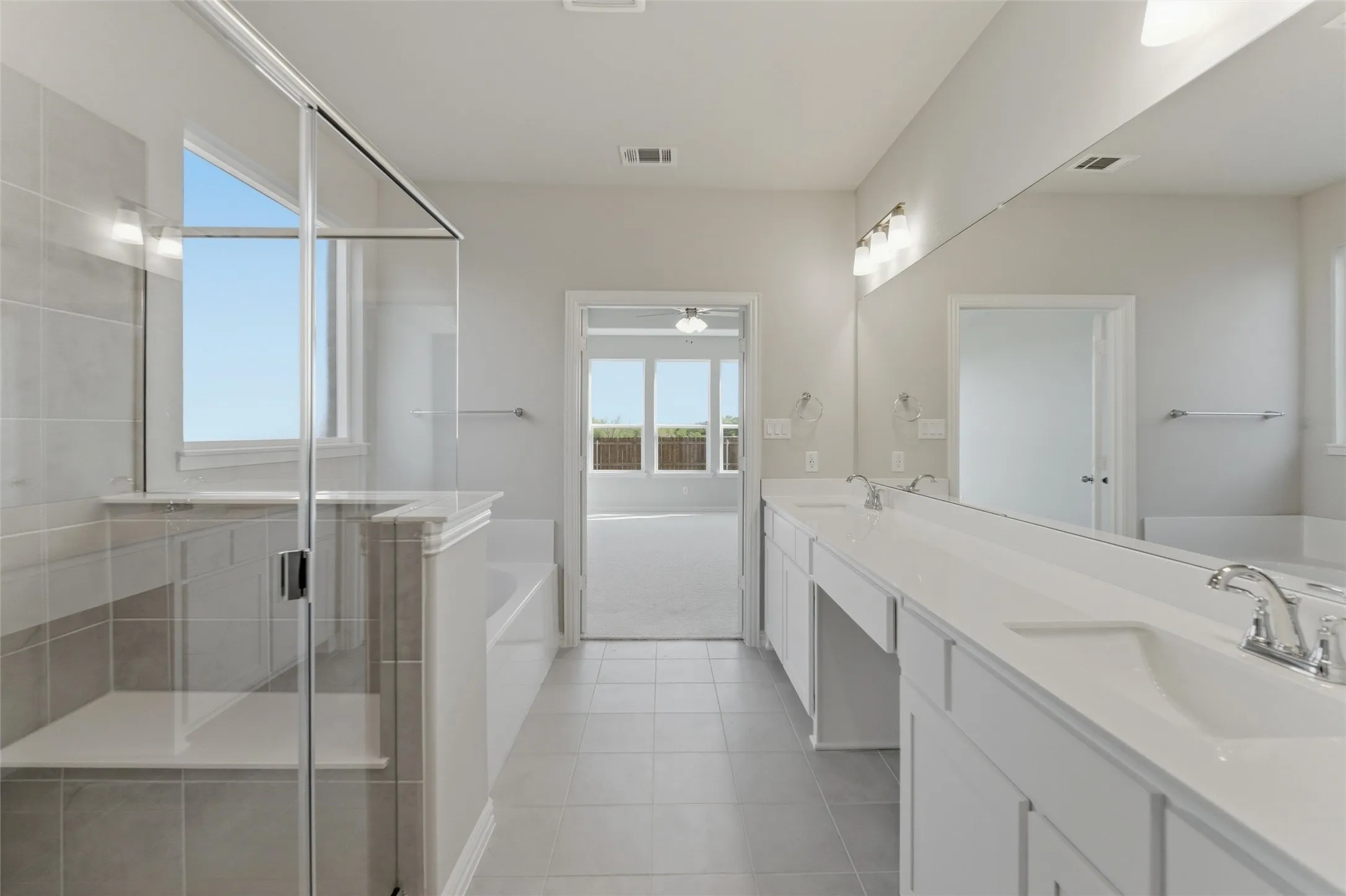 Bathroom with a bath, double vanity, a stall shower, light tile patterned floors, and light colored carpet