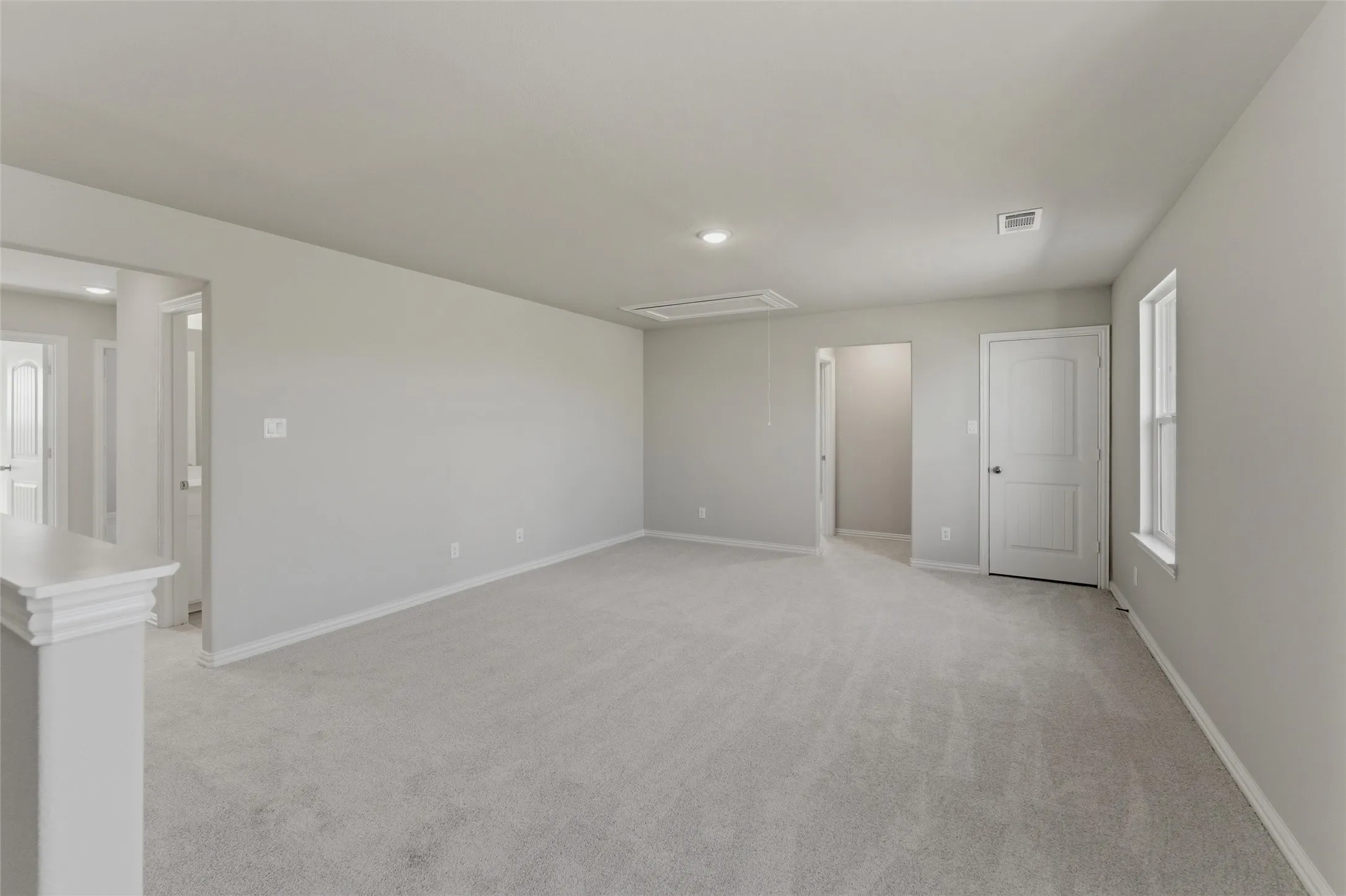 Unfurnished bedroom with multiple windows and light carpet