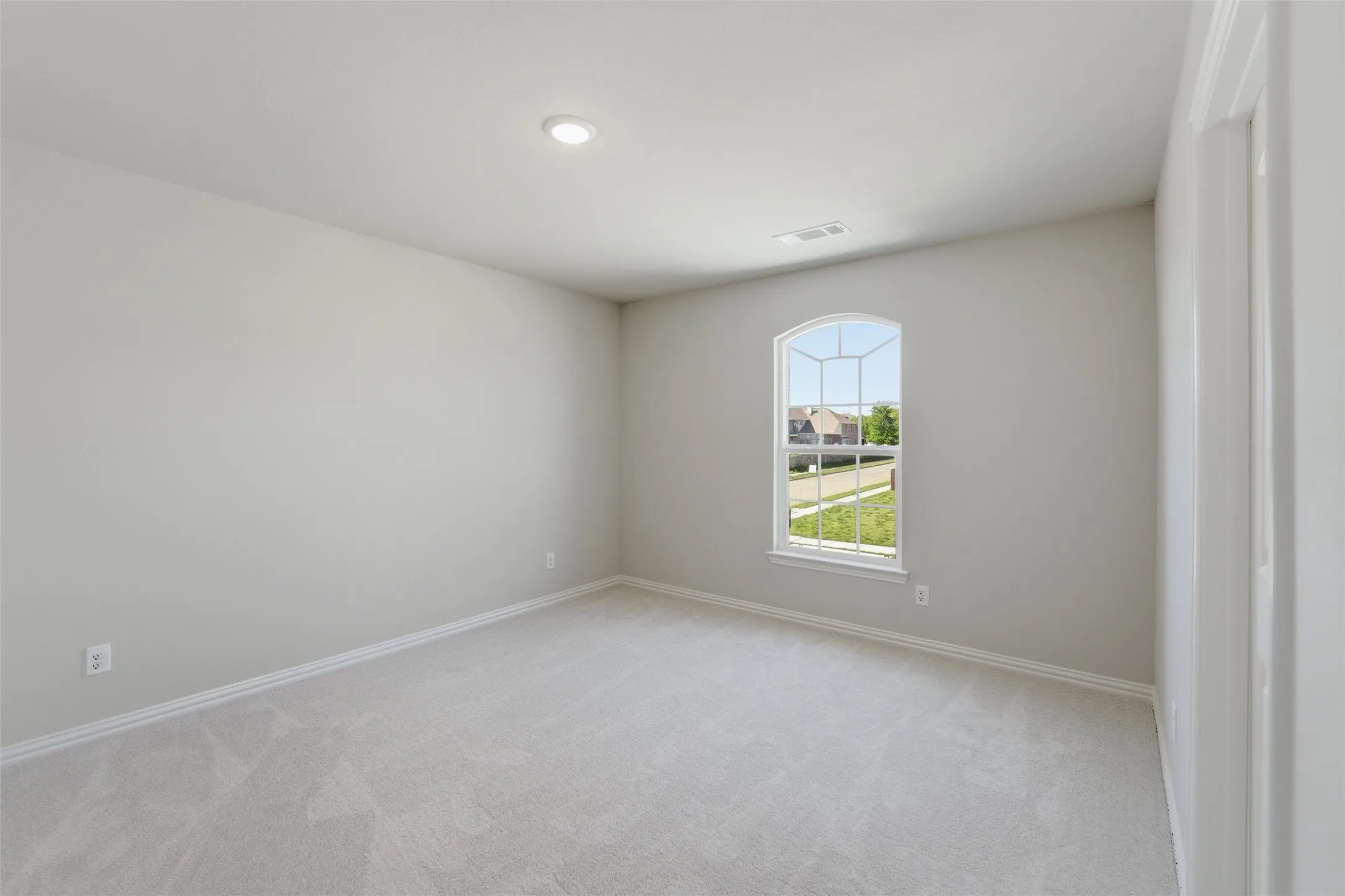 Spare room featuring light carpet and baseboards