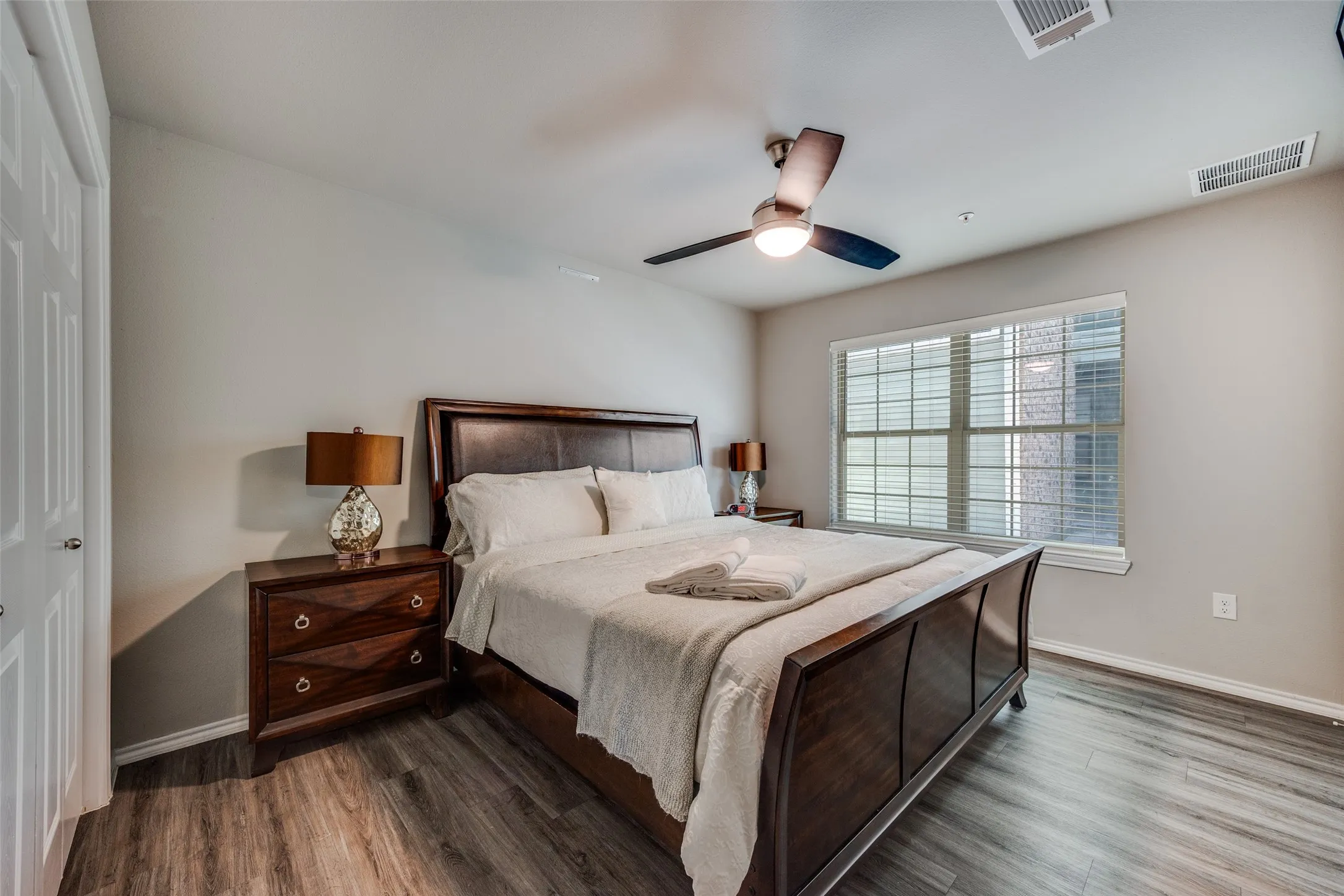 Bedroom with ceiling fan and dark wood-style flooring