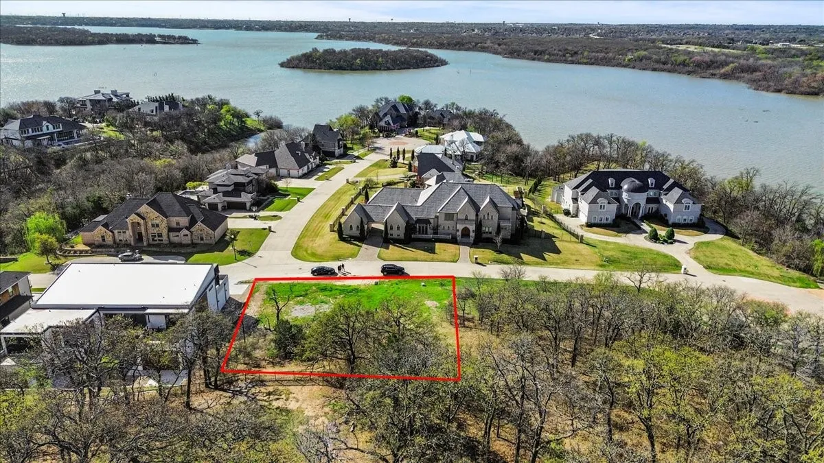 Aerial perspective of suburban area featuring property parcel outlined and a nearby body of water