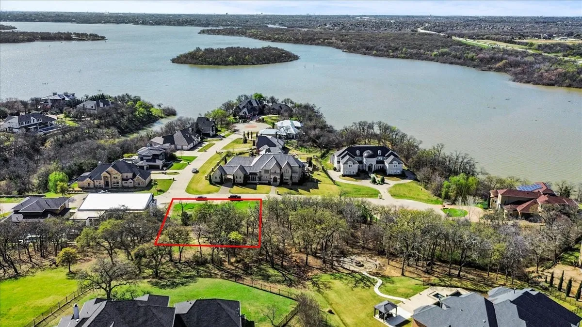 Aerial perspective of suburban area featuring property parcel outlined and a large body of water