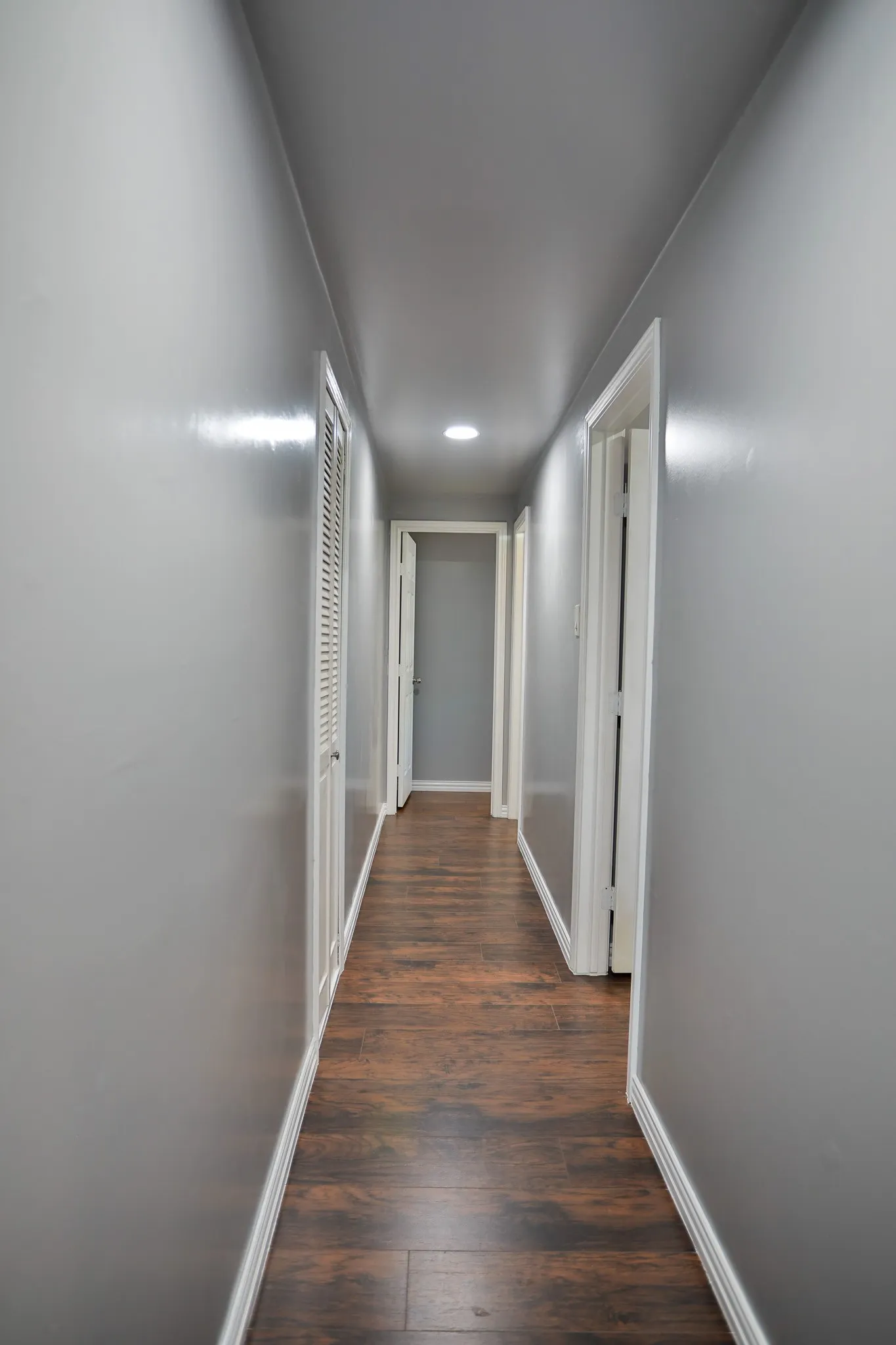 Hallway with wood-finish flooring, recessed lighting, and grey walls