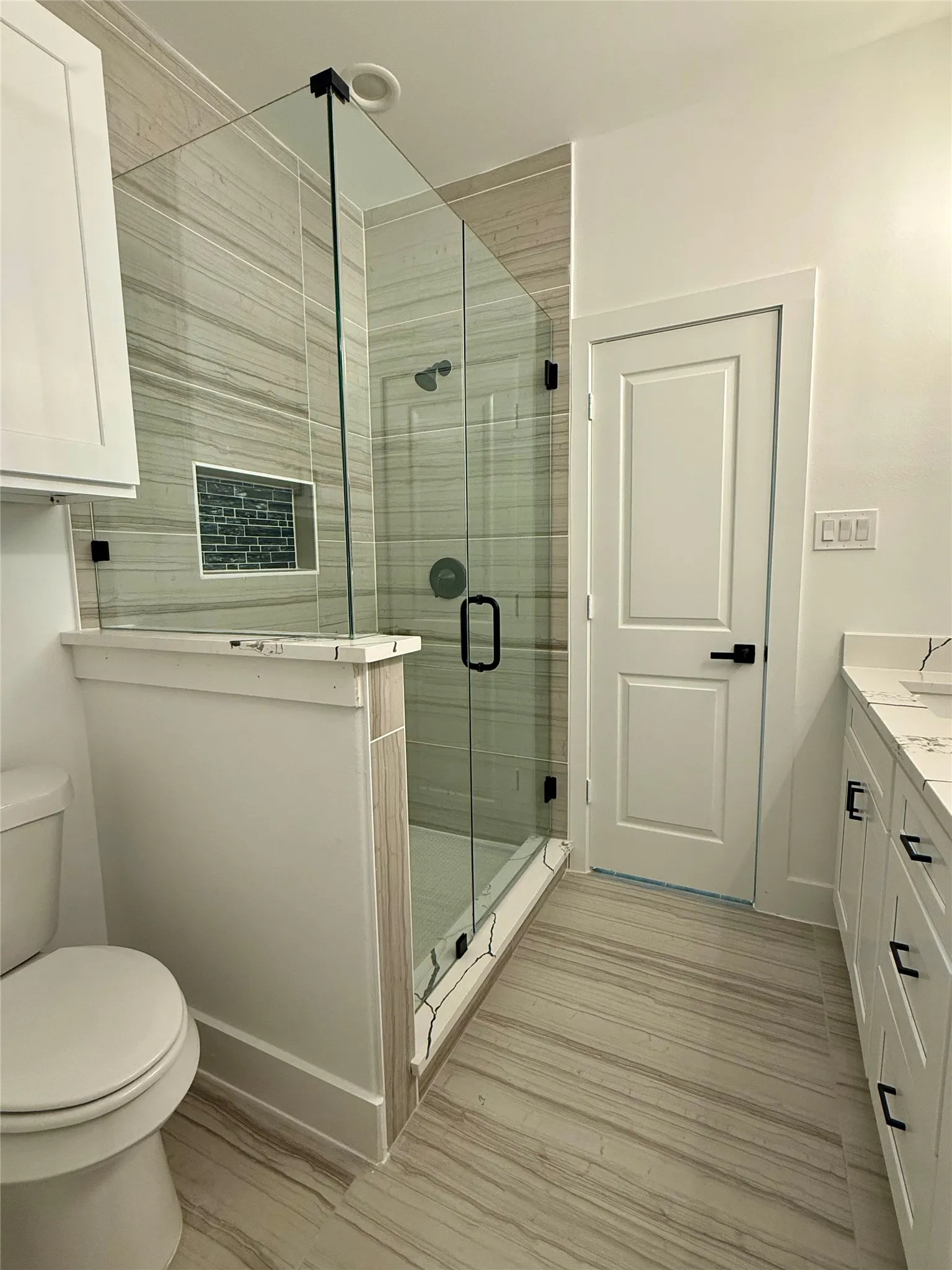 Bathroom featuring a shower stall, vanity, and light wood finished floors