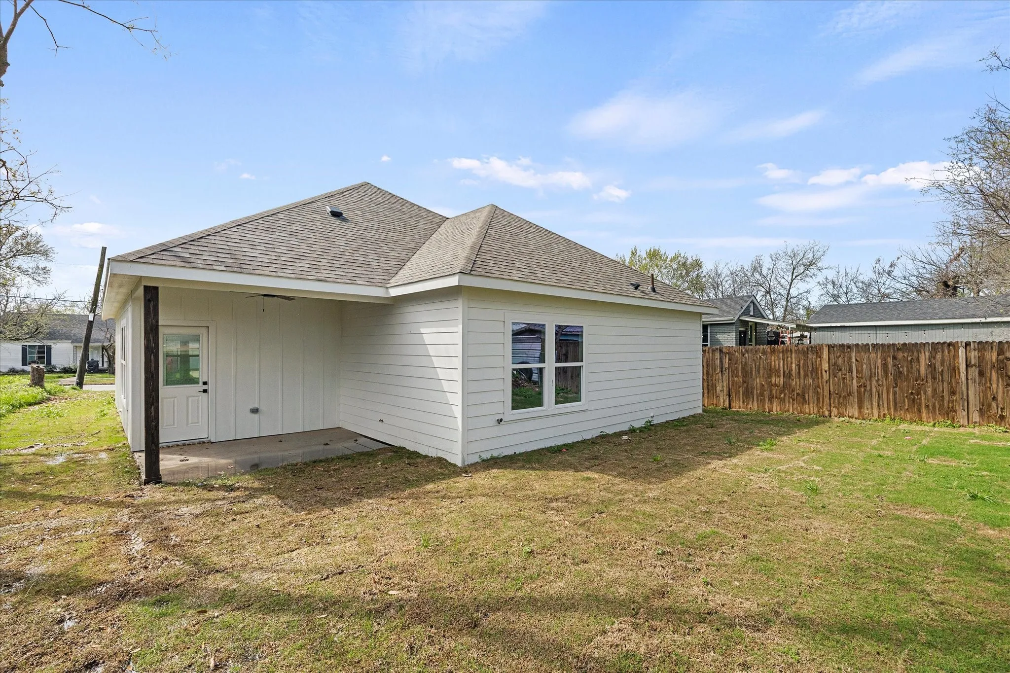 View of home's exterior featuring a patio area, a shingled roof, and board and batten siding