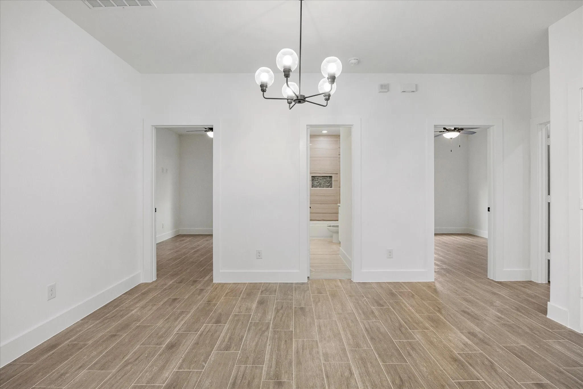 Unfurnished dining area featuring wood finish floors, a ceiling fan, and suspended lighting
