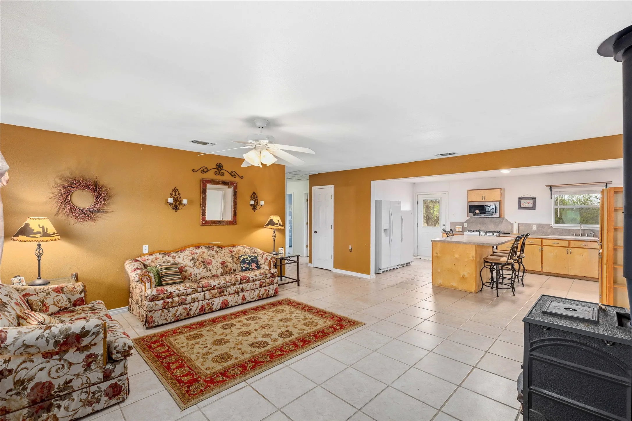 large living room has a wood burning stove and great flow to kitchen.