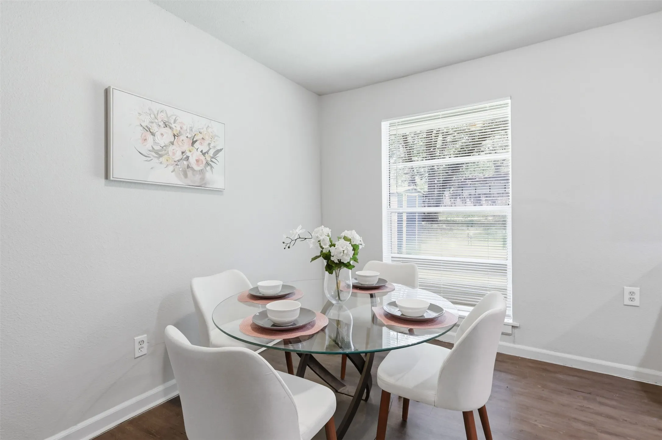 Dining area with laminate flooring and large window with plenty of space for family gatherings.