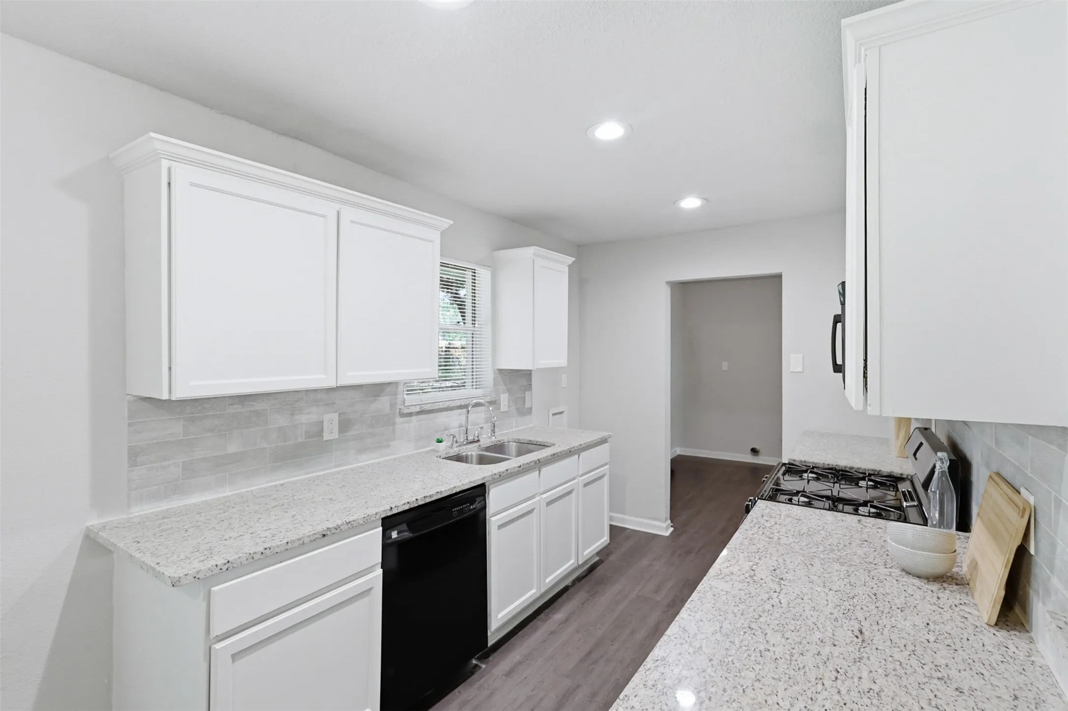 Gas range with long granite countertops allow for lots of prep space.