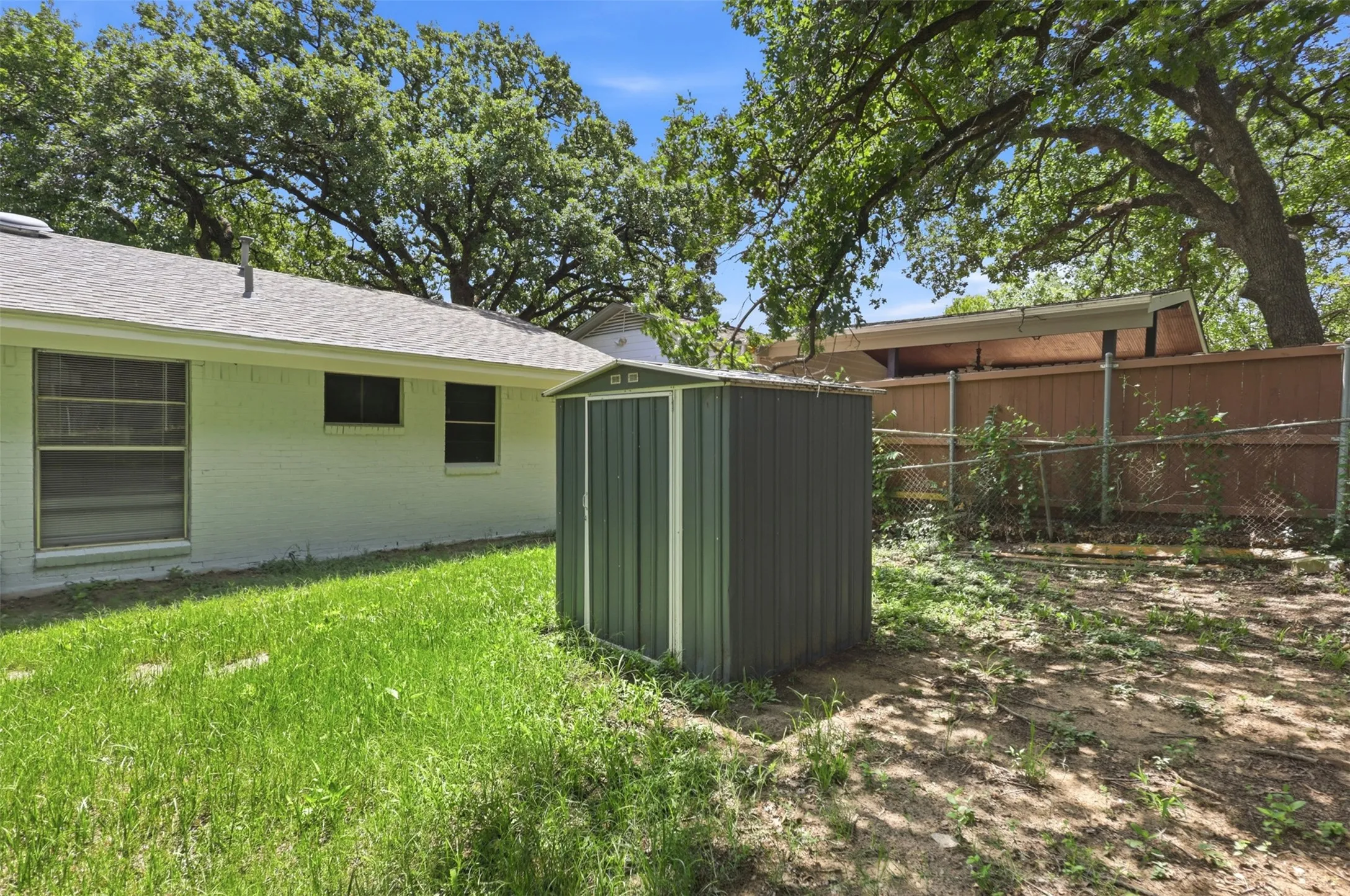 Storage shed in backyard perfect for storing lawn equipment.