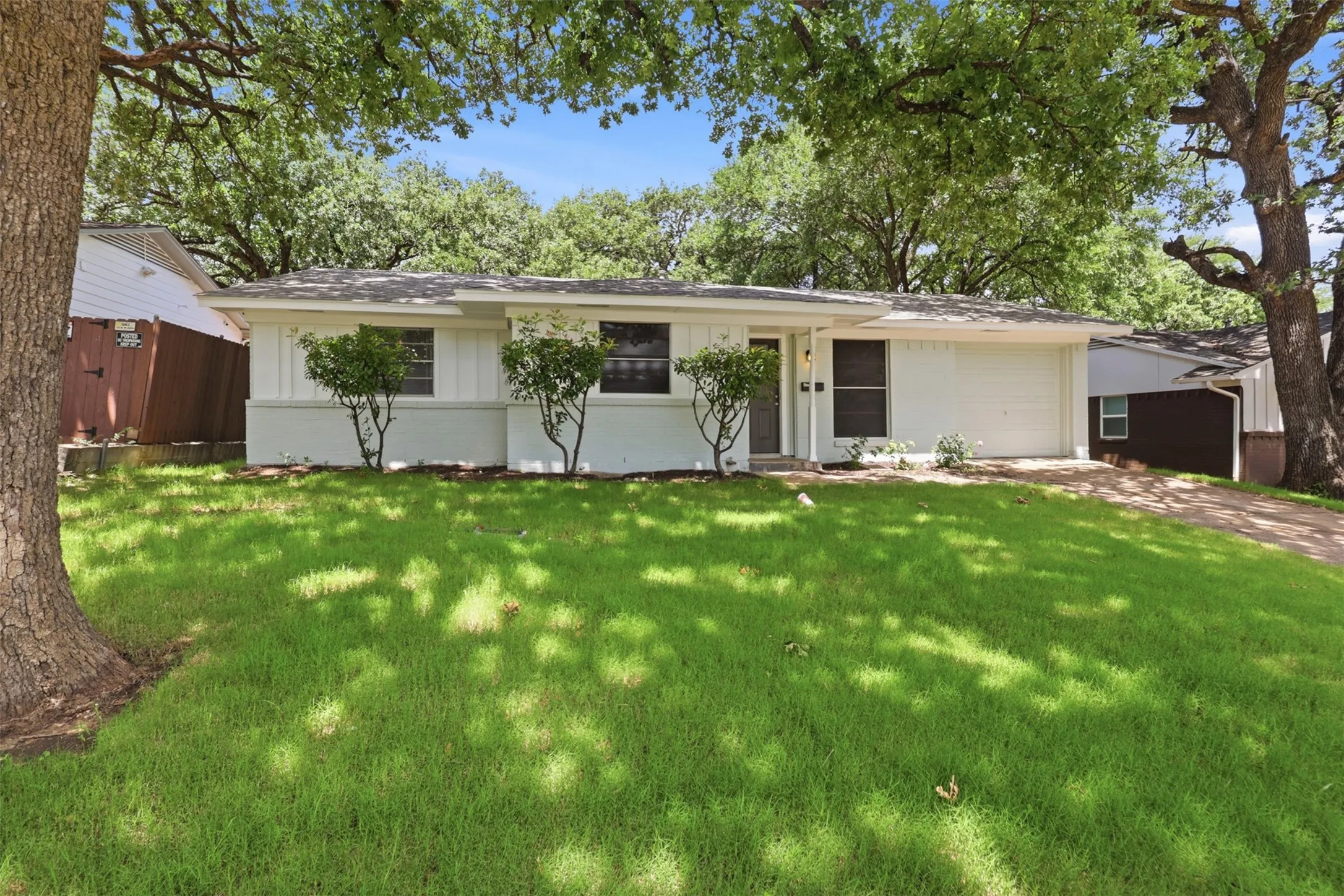 Beautiful front of home with freshly laid sod and mature trees.  Grass has been photoshopped to show potential.