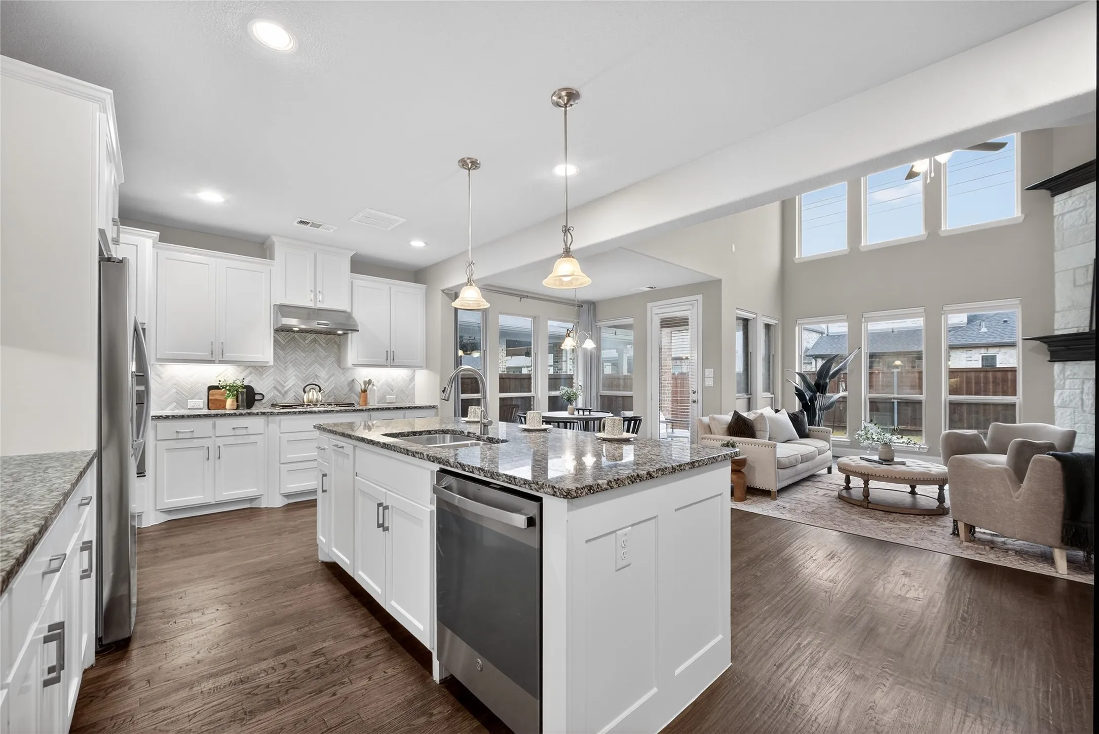 Kitchen featuring dark wood-style flooring, white cabinets, stainless steel appliances, and open floor plan