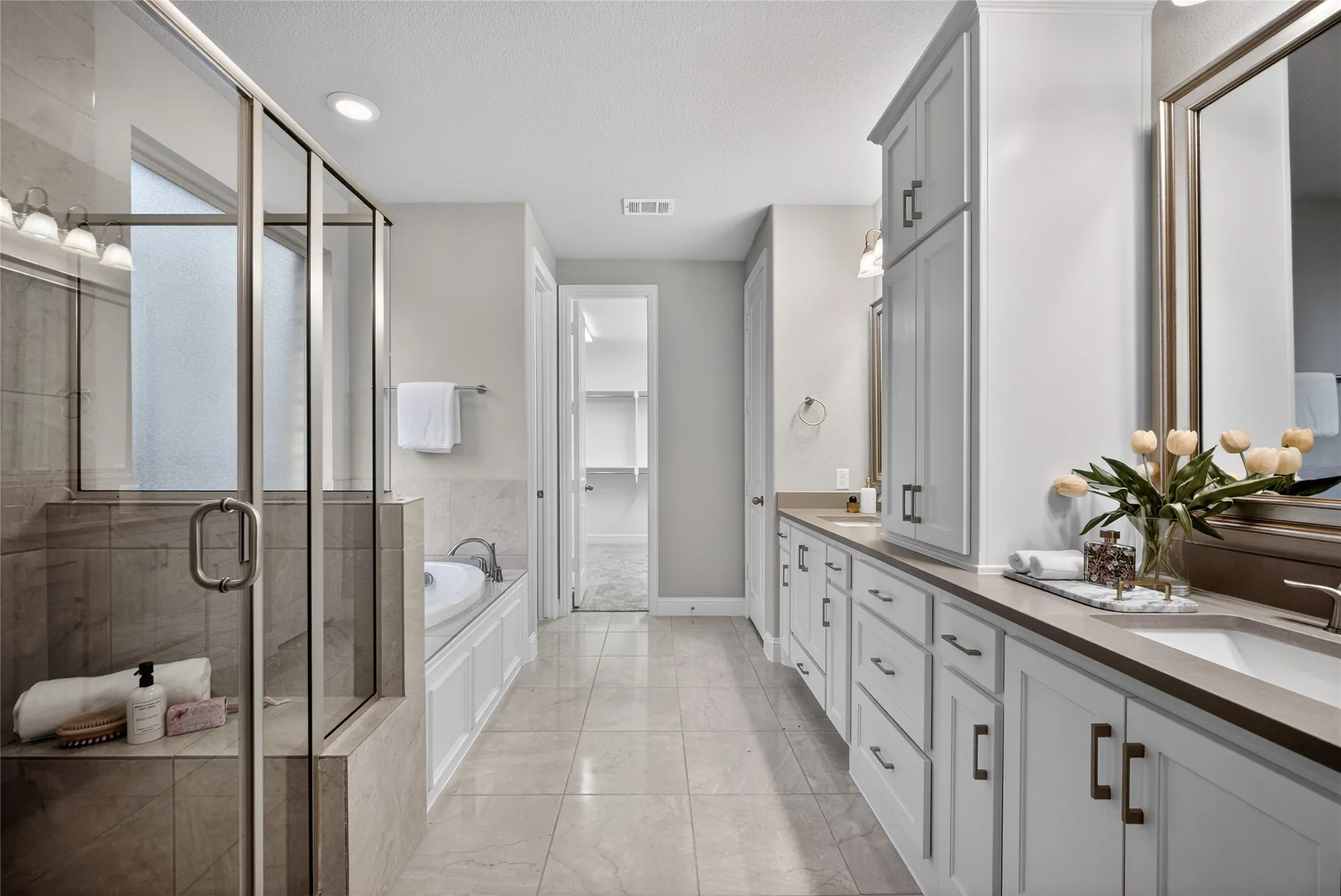 Full bathroom with double vanity, a stall shower, a garden tub, and recessed lighting