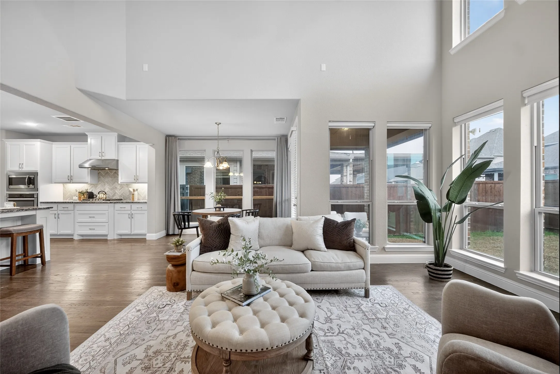 Living area featuring dark wood-type flooring, a high ceiling, and hanging lights