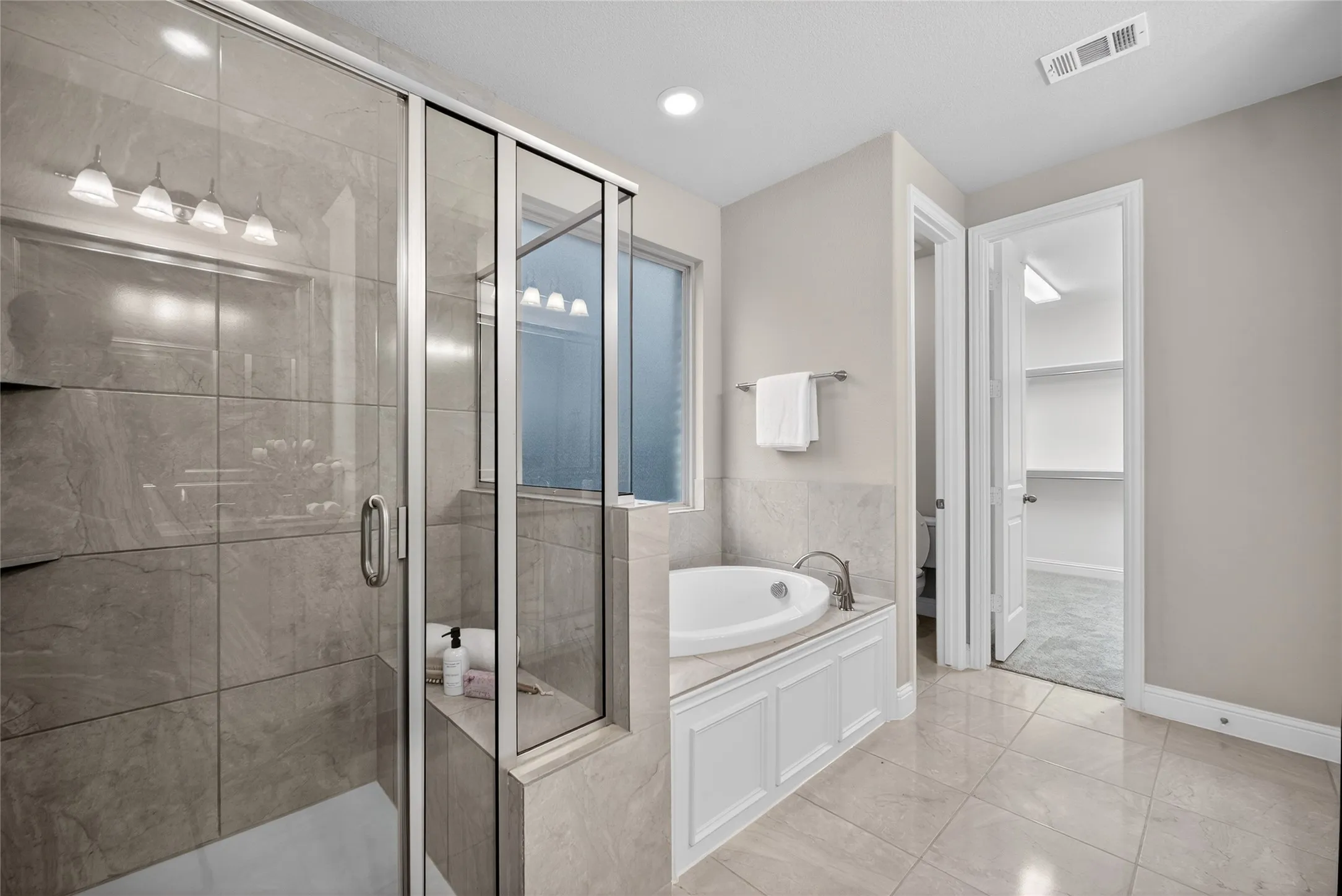 Bathroom featuring a shower stall, a bath, light tile patterned flooring, a spacious closet, and recessed lighting