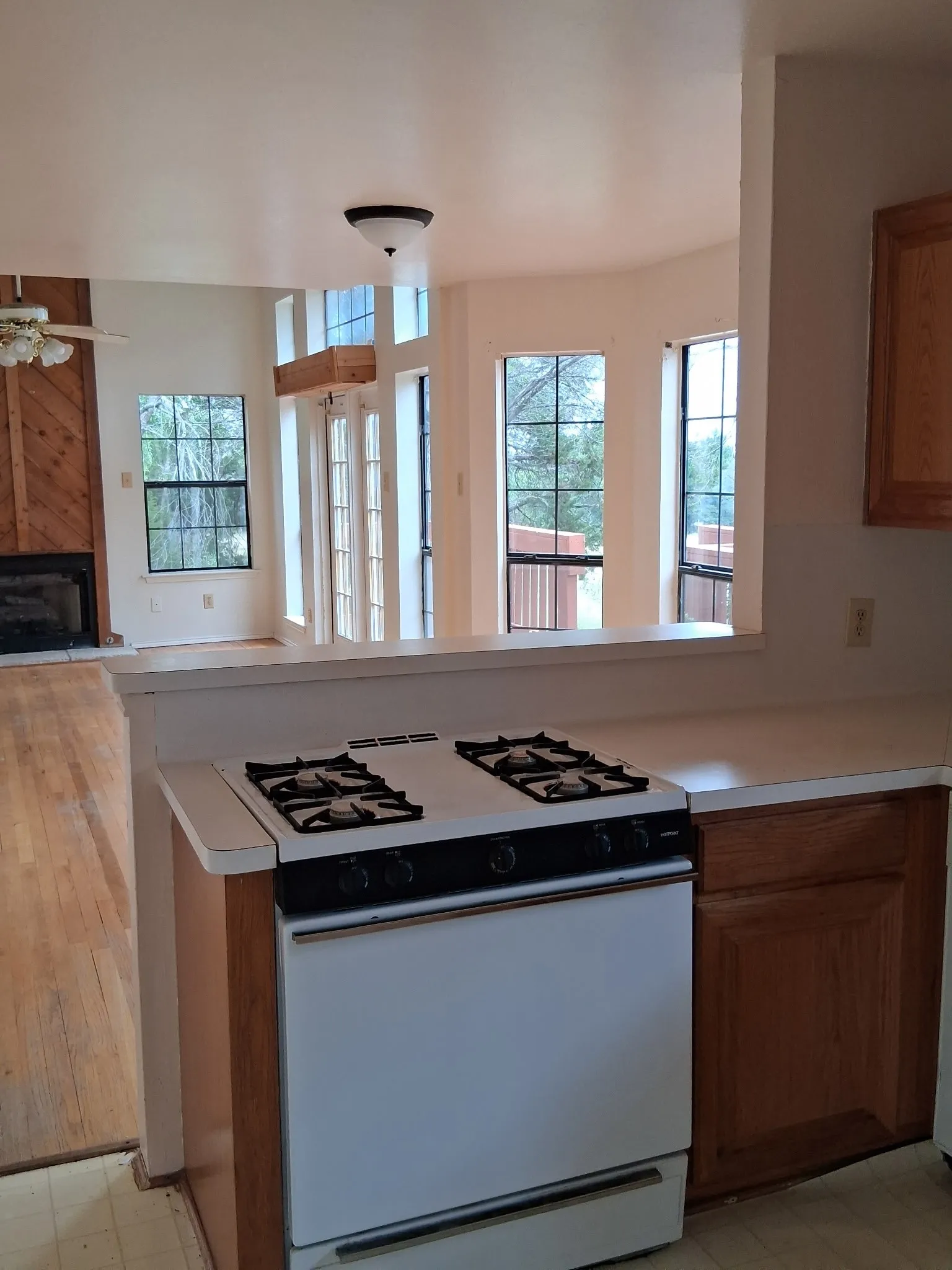Kitchen area featuring a white gas range, light-toned countertops, and wood cabinetry
