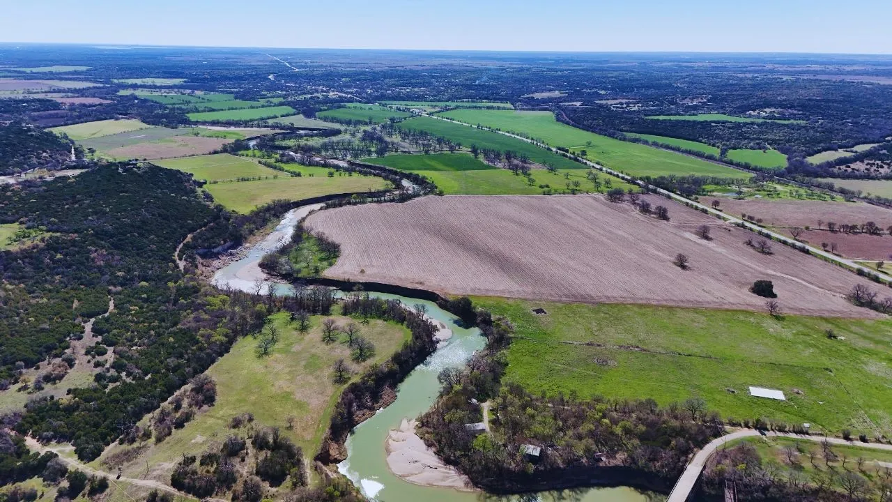 Aerial view of property and surrounding area featuring rural landscape and extensive farmland