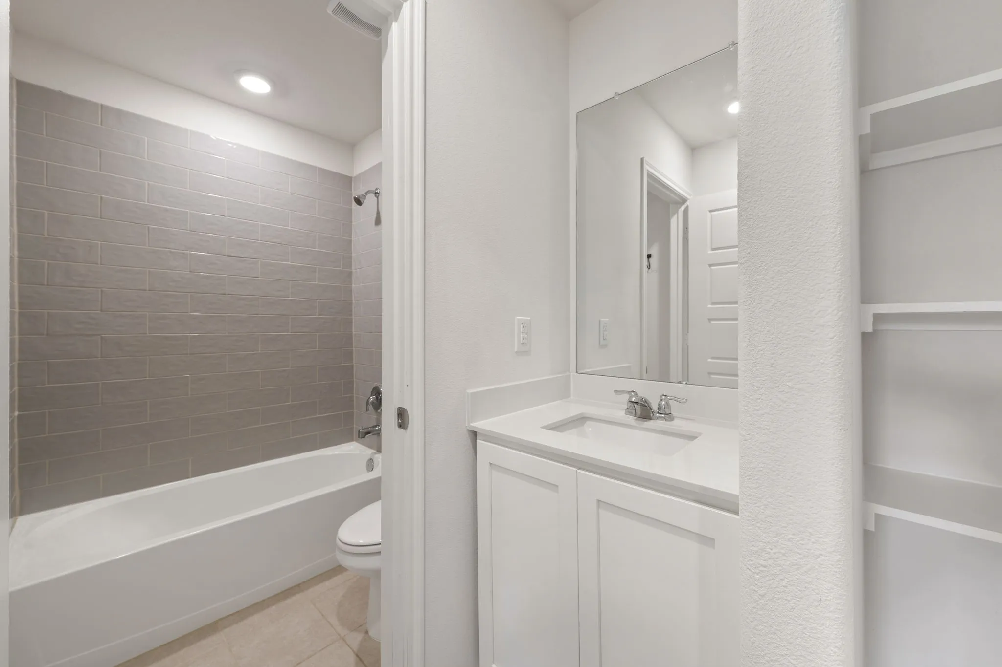Bathroom featuring a white vanity with a light-toned countertop, a rectangular undermount sink, and a framed mirror