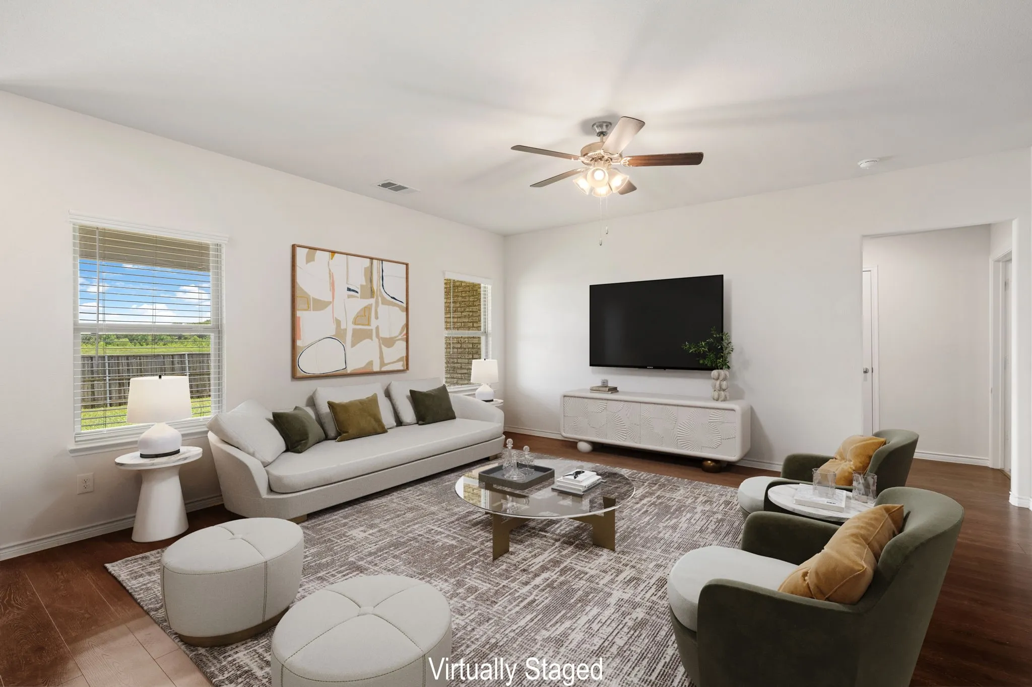 Open-concept living space featuring wood-finish flooring, white walls, and a ceiling fan