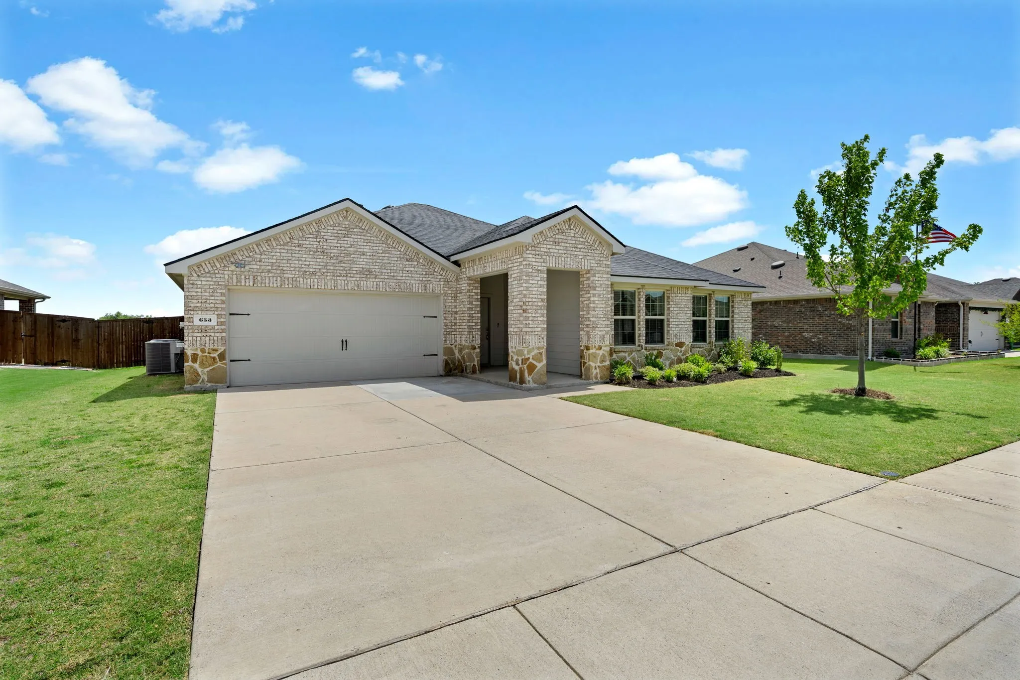 Single-story residence featuring a light brick facade with stone accents and BRAND NEW BLACK ROOF!