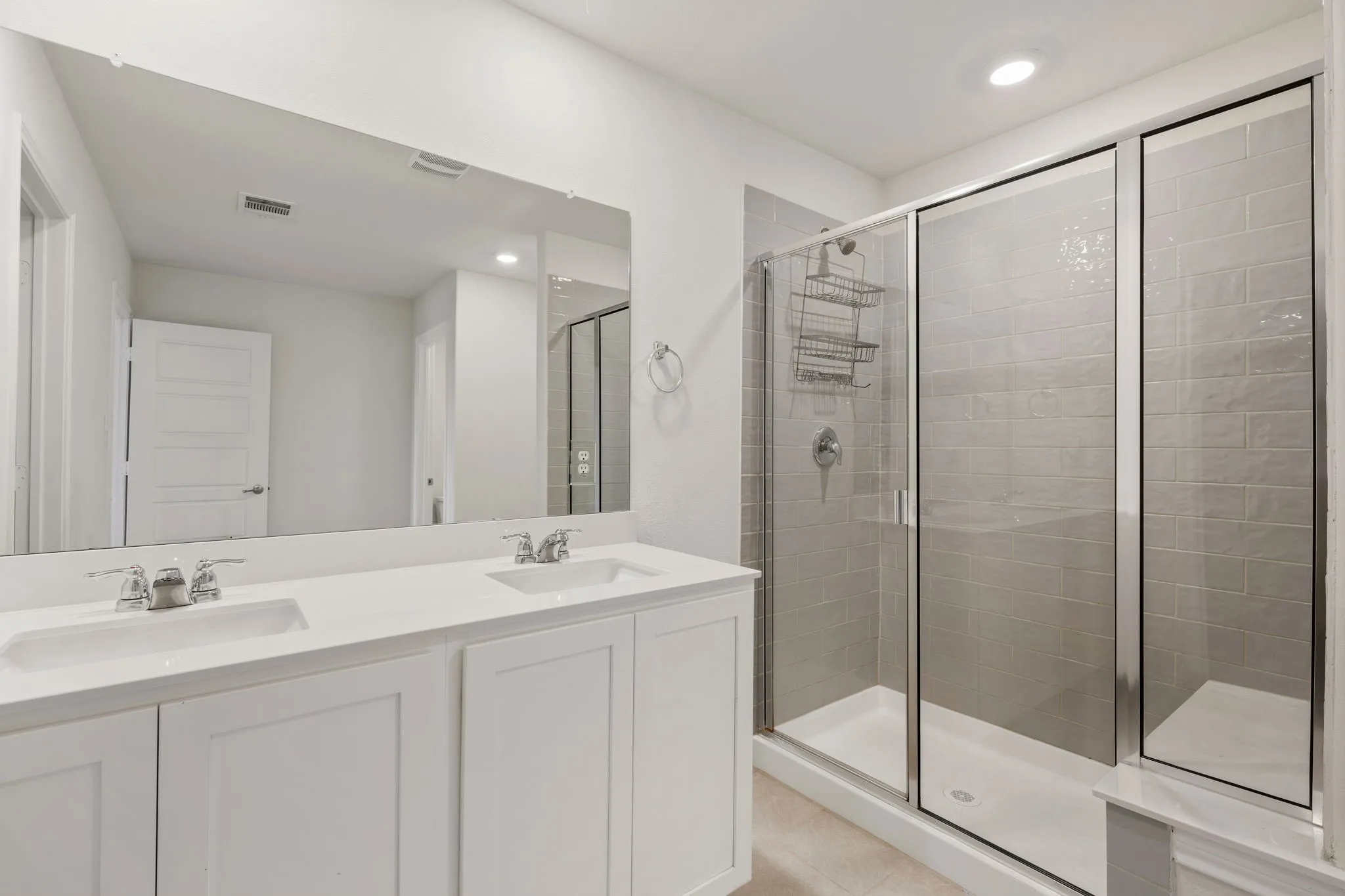 Contemporary bathroom featuring a spacious dual-sink vanity with white cabinetry and chrome fixtures