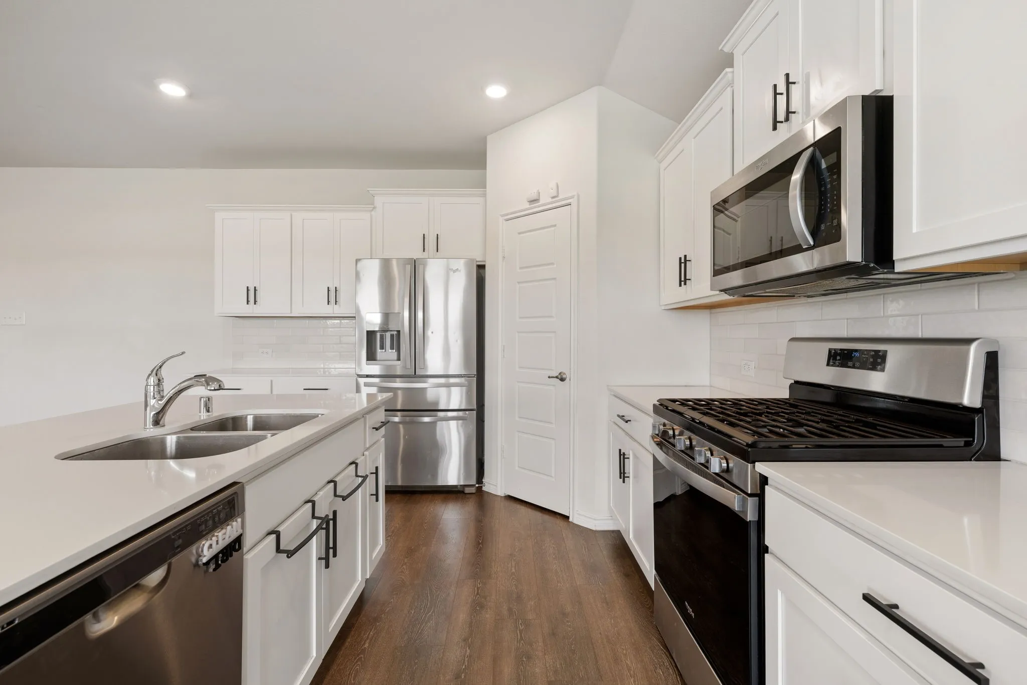 Contemporary kitchen featuring white cabinetry and stainless steel appliances