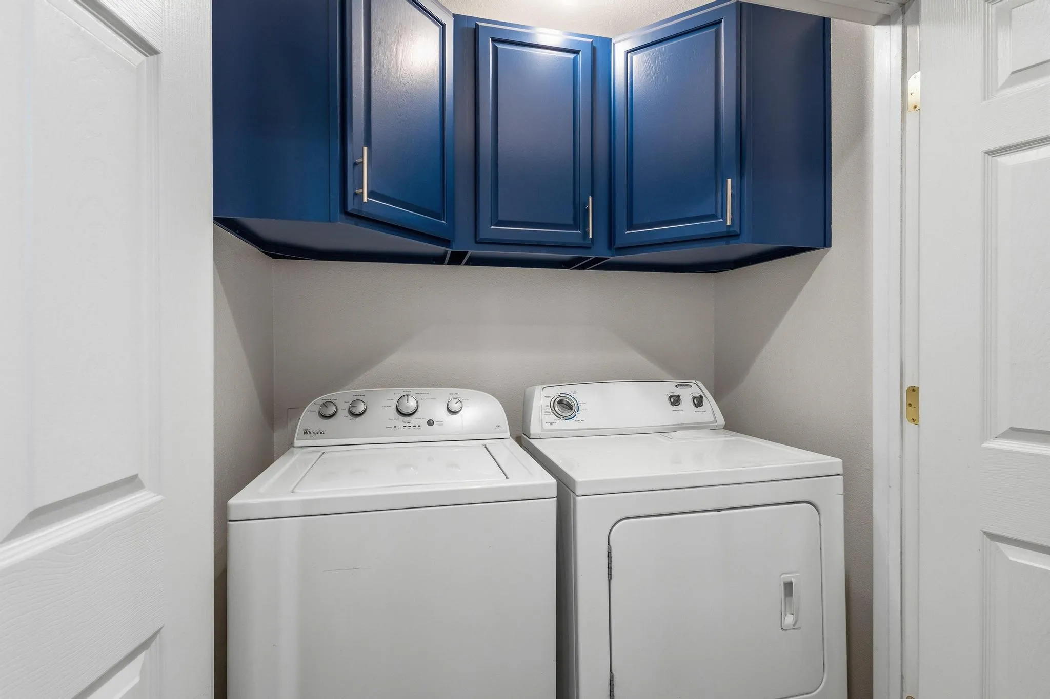 Laundry room featuring separate washer and dryer and cabinet space
