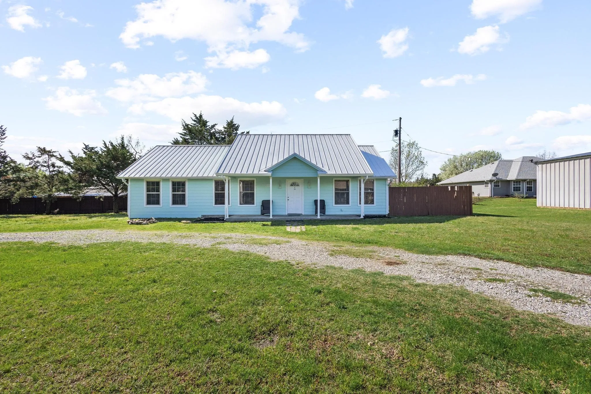 View of front facade with covered porch and a standing seam roof